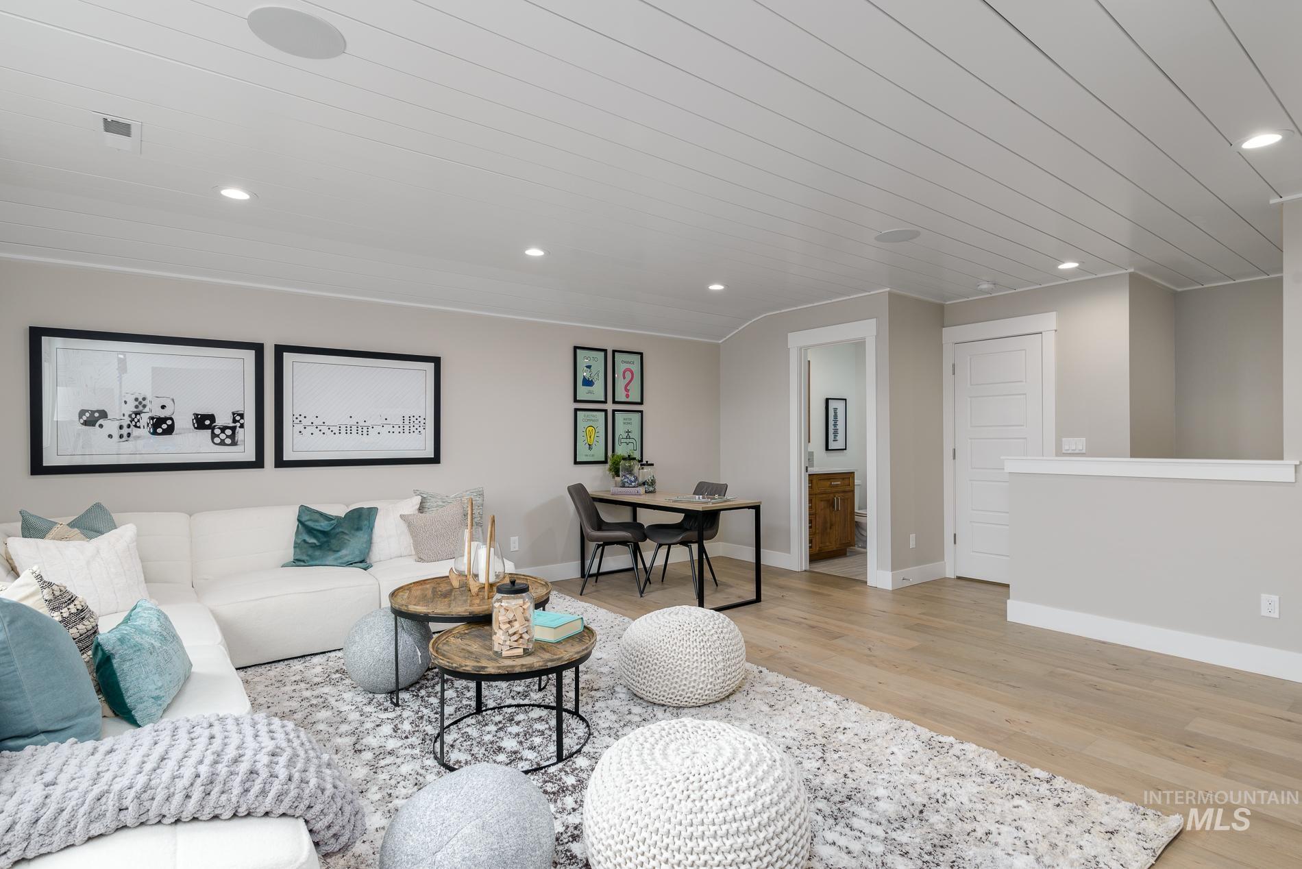 Living area with light wood-type flooring and recessed lighting