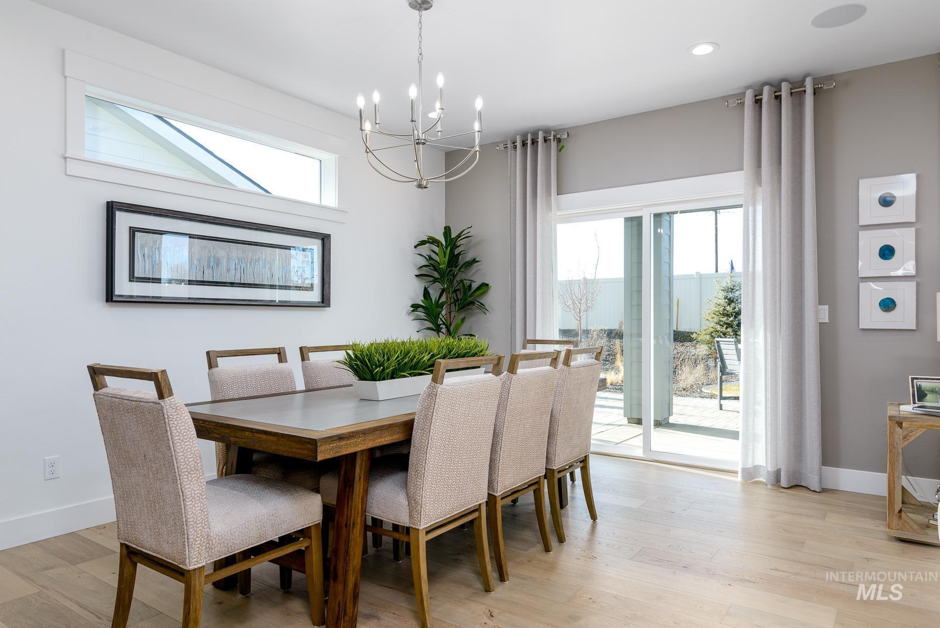 Dining space with healthy amount of natural light, light wood-style flooring, a chandelier, and recessed lighting