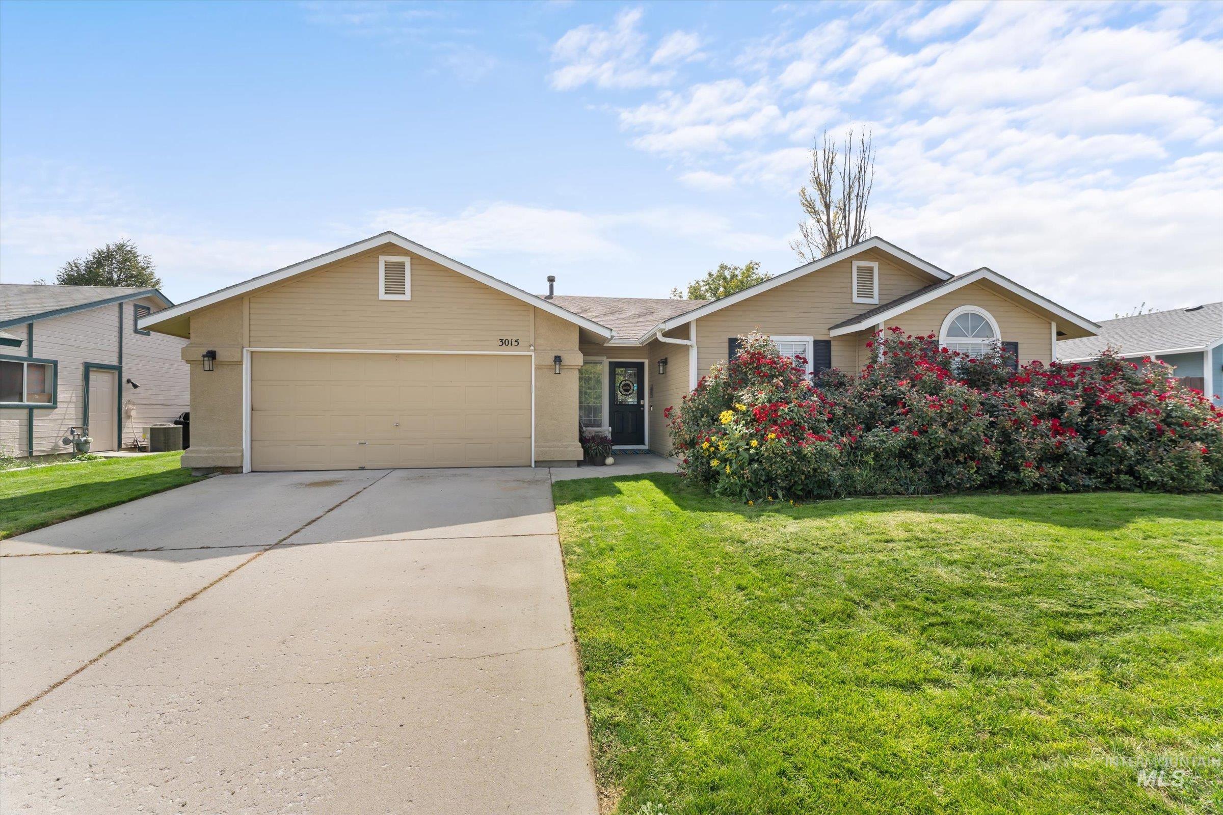 Single story home featuring a front lawn, driveway, and a garage