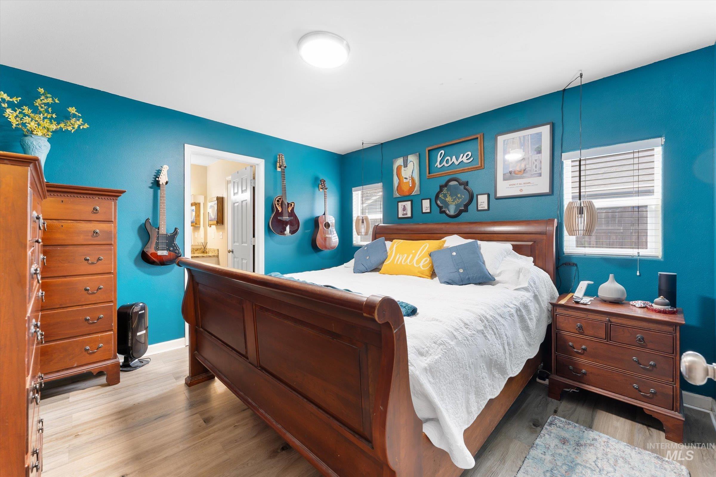 Bedroom with light wood-type flooring and ensuite bathroom