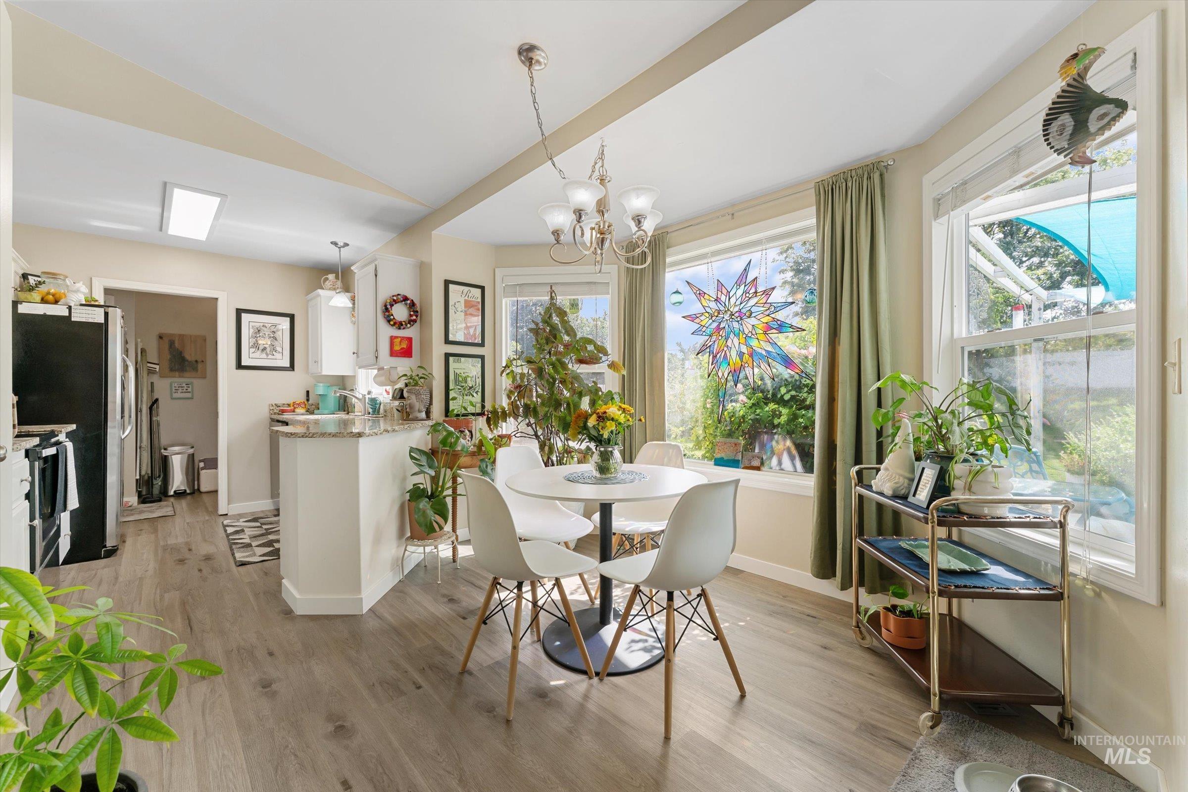Dining area with light wood-style flooring and a chandelier
