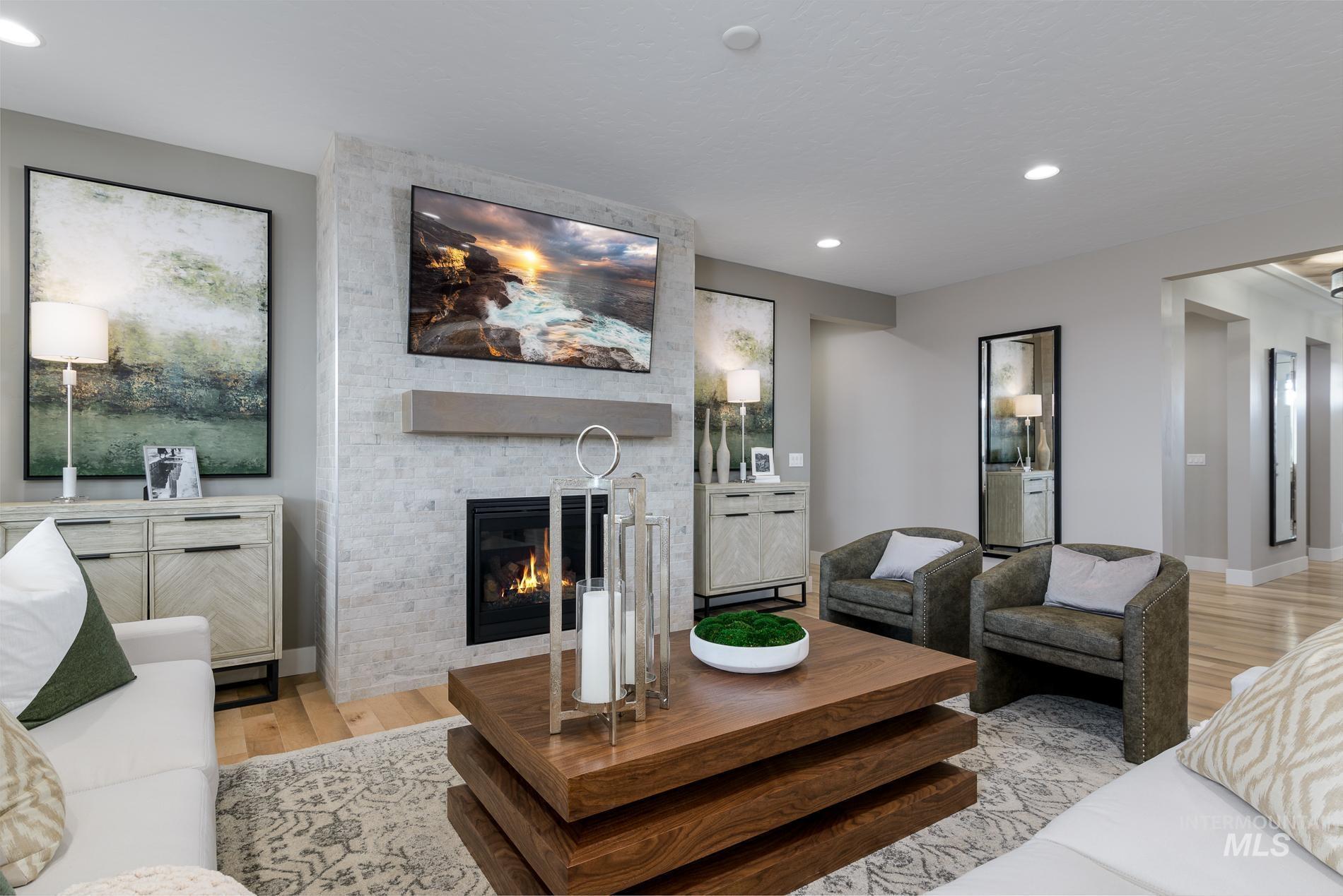 Living room with light wood finished floors, recessed lighting, and a fireplace