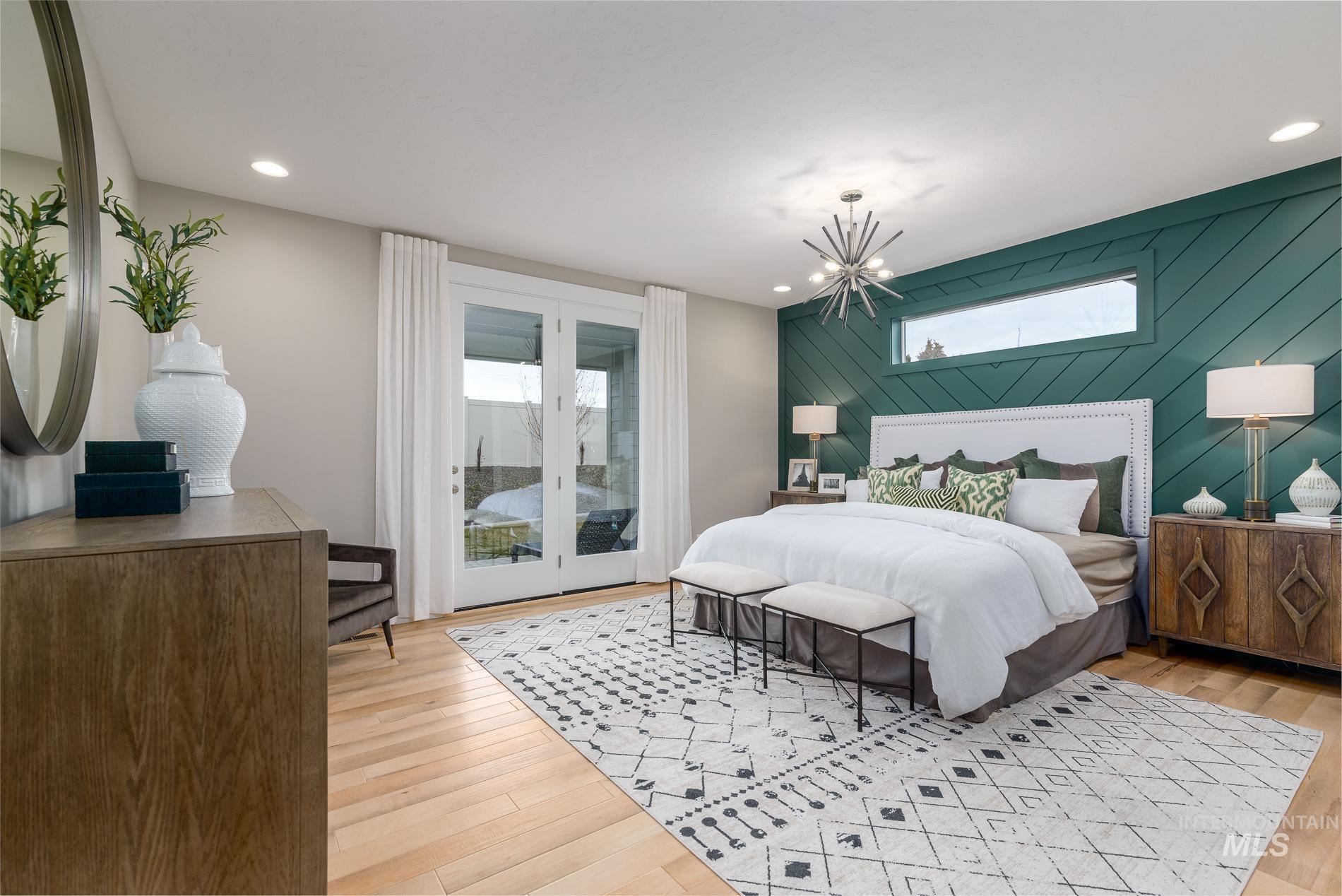 Bedroom featuring multiple windows, light wood-style floors, access to exterior, wooden walls, and a chandelier
