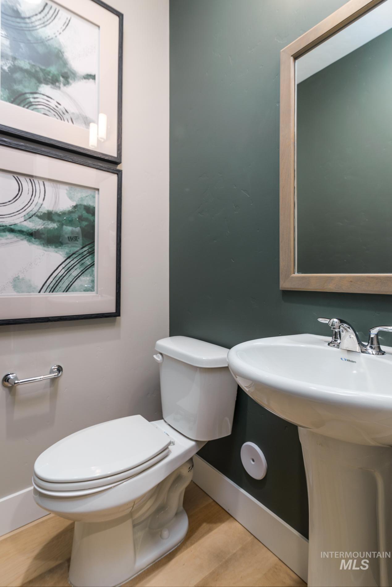 Half bathroom featuring light wood-type flooring and toilet
