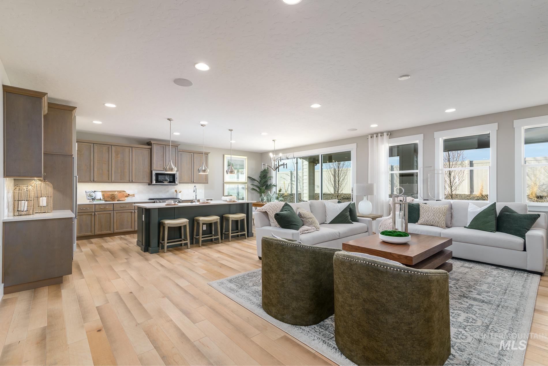 Living room with healthy amount of natural light, light wood-type flooring, recessed lighting, and a chandelier