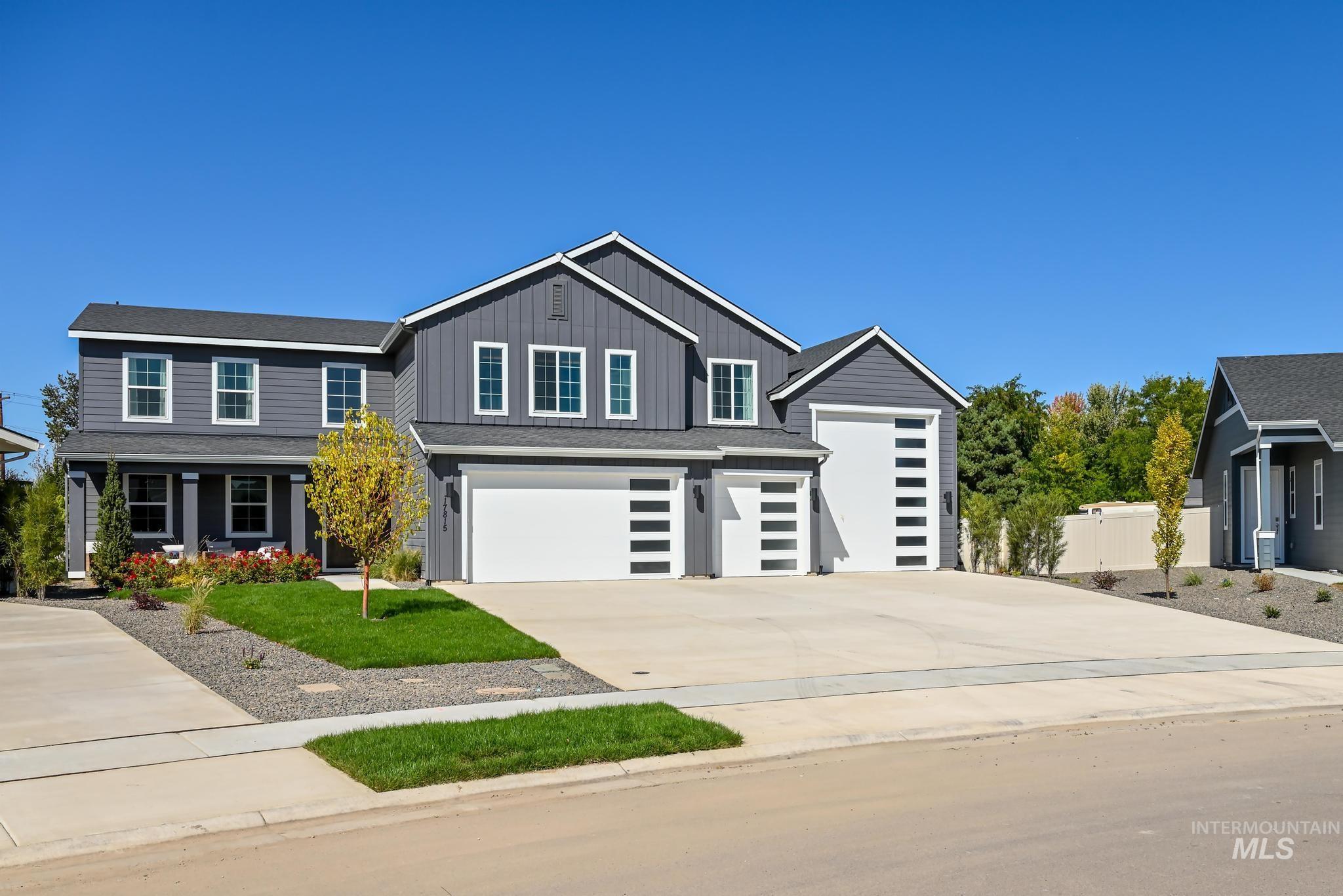 View of front facade featuring driveway, board and batten siding, and a garage
