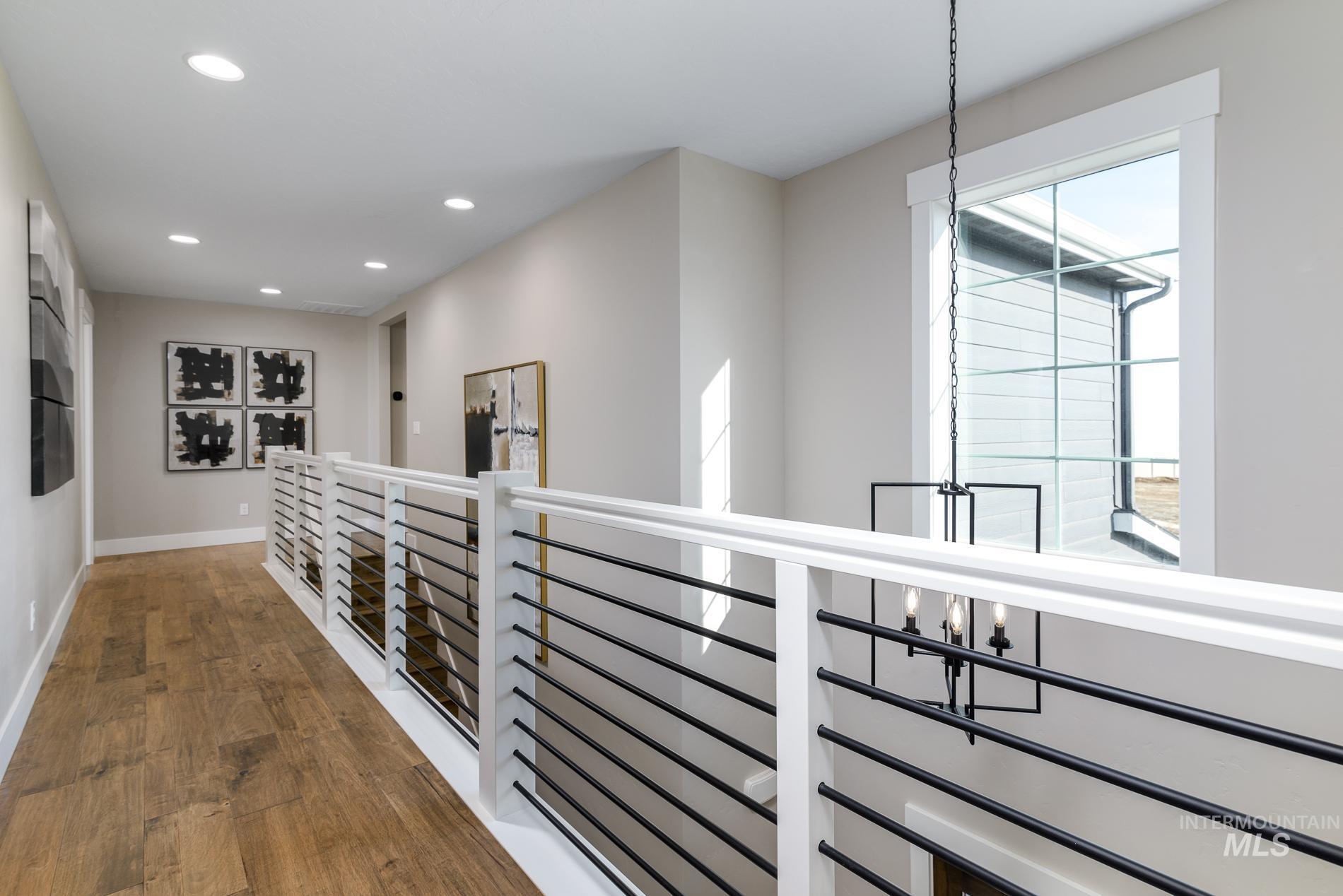 Hallway featuring recessed lighting, wood finished floors, and an upstairs landing