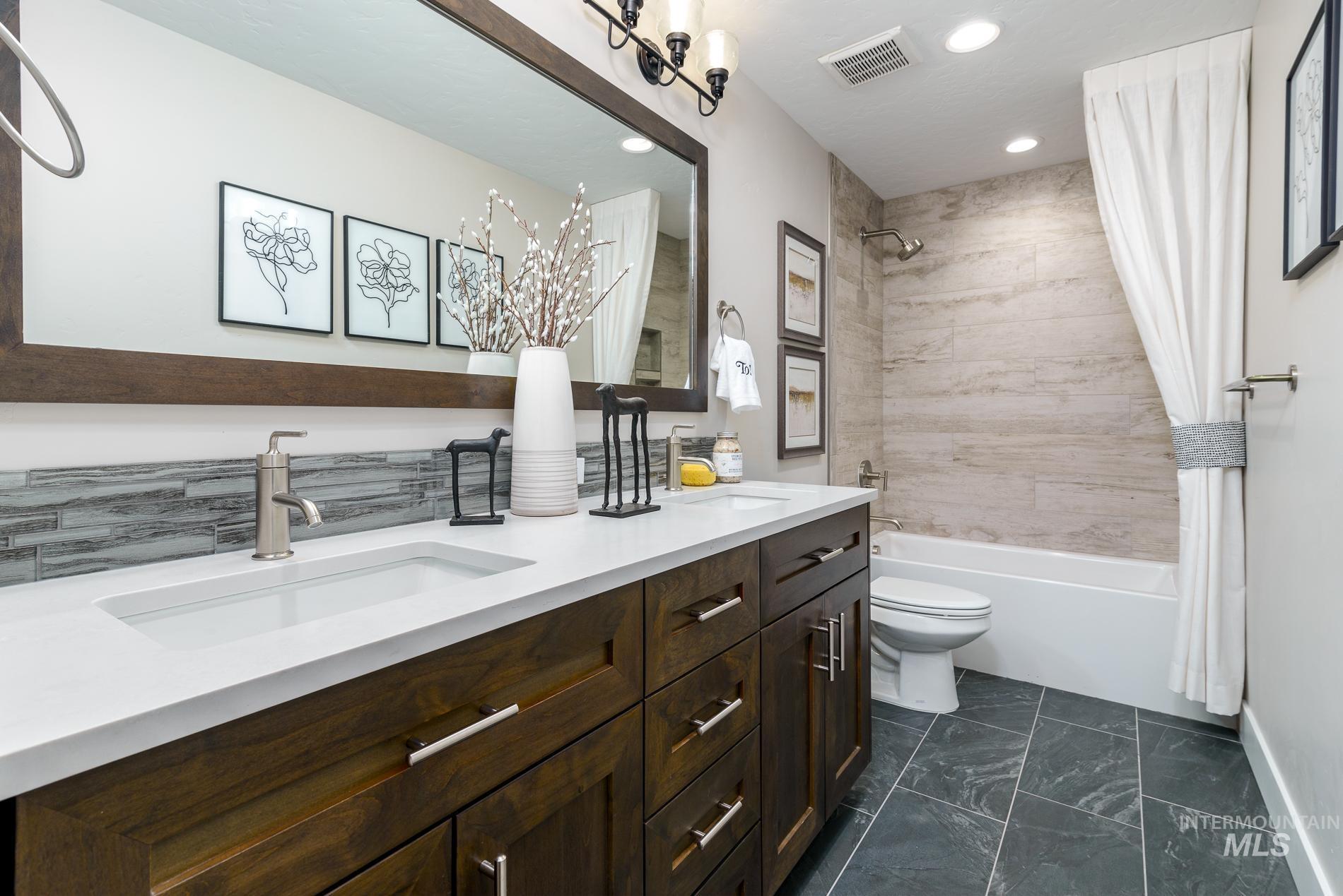 Bathroom with shower / bath combo, double vanity, recessed lighting, and dark marble finish floors
