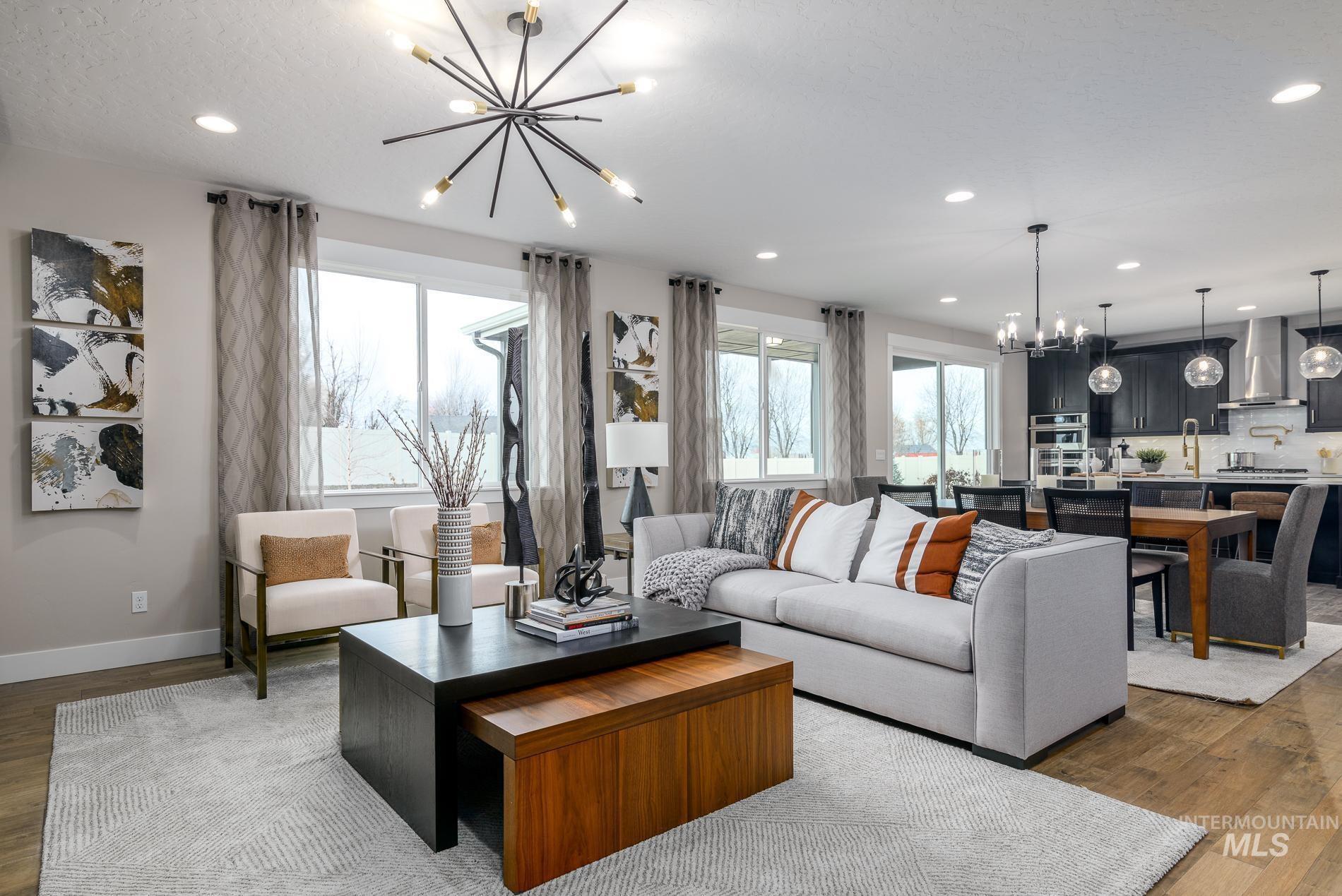 Living area with a chandelier, dark wood-style flooring, and recessed lighting