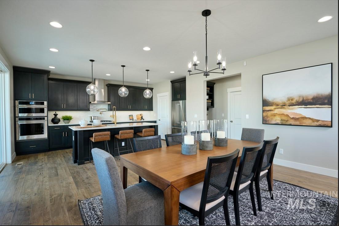 Dining space featuring a chandelier, dark wood-style floors, and recessed lighting