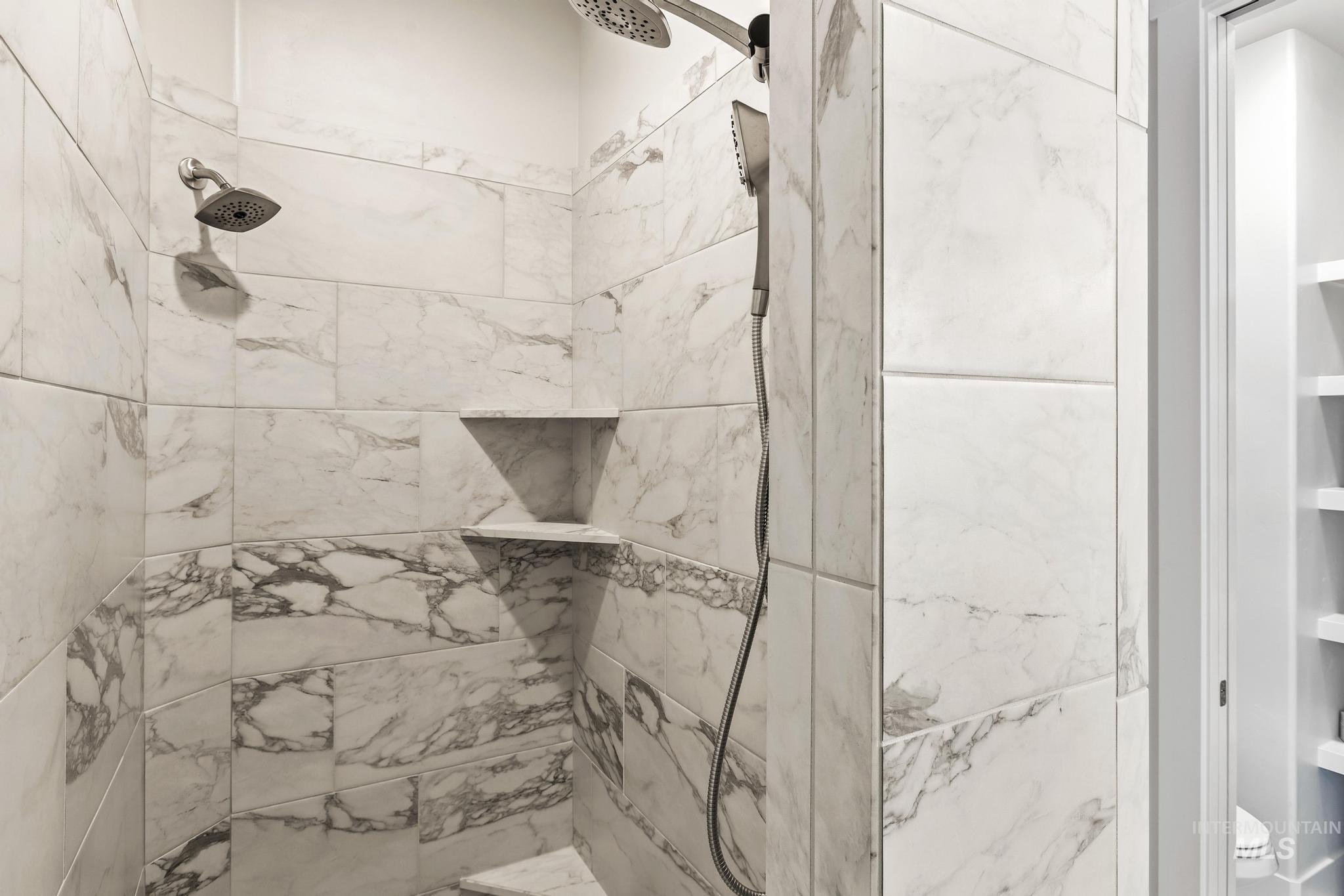 Bathroom view of a shower stall and toilet