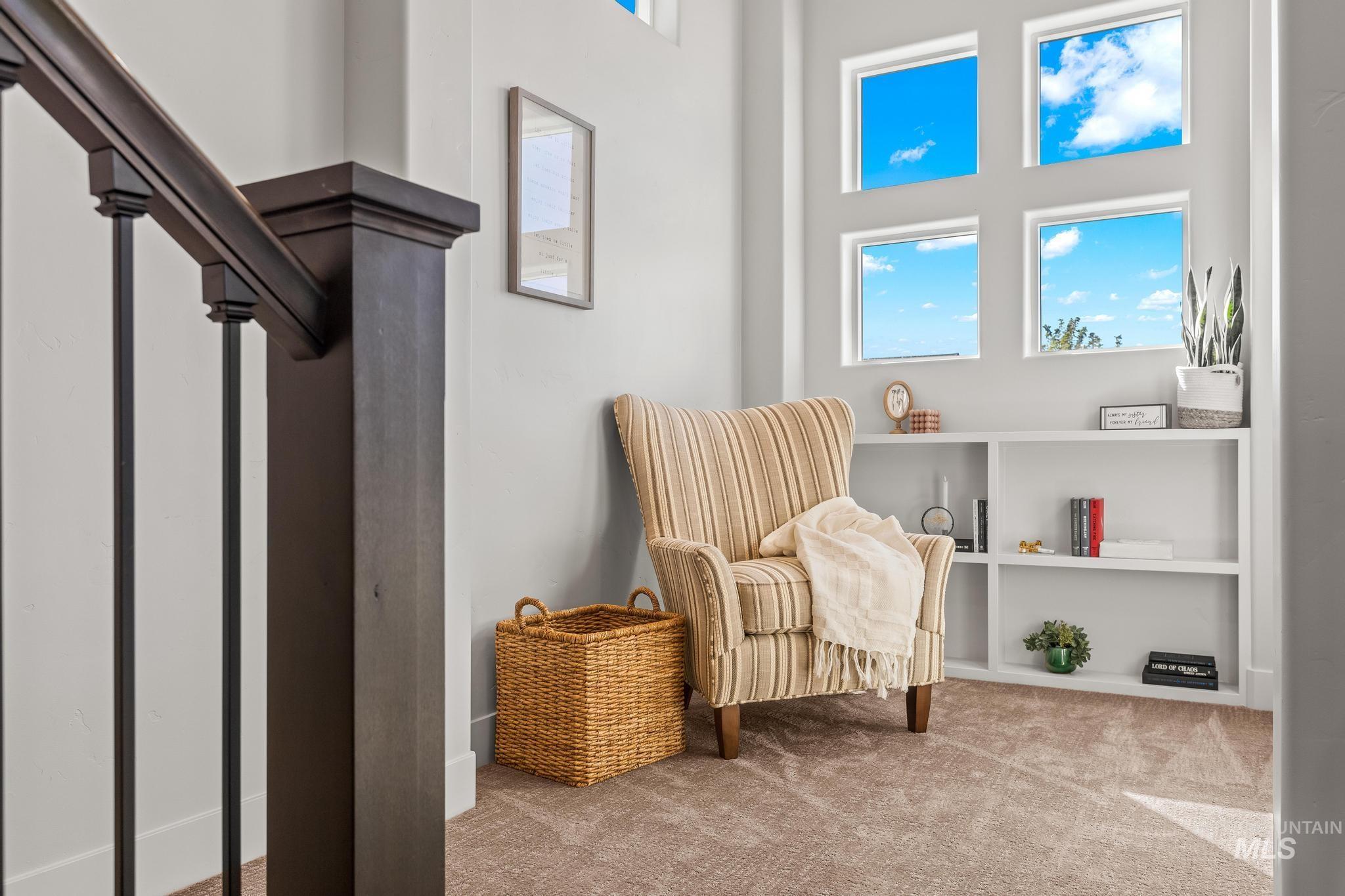 Living area featuring plenty of natural light, carpet floors, and a high ceiling