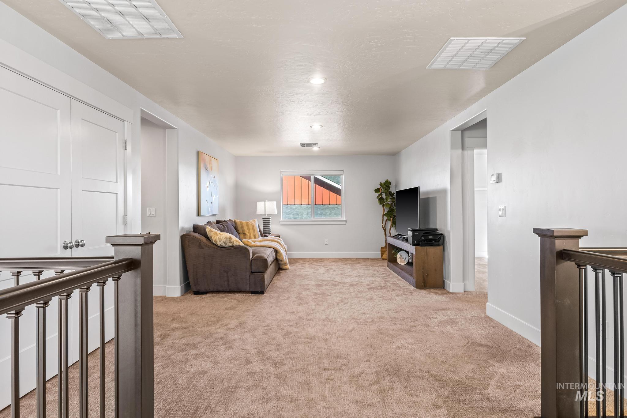 Living area with light colored carpet and a textured ceiling