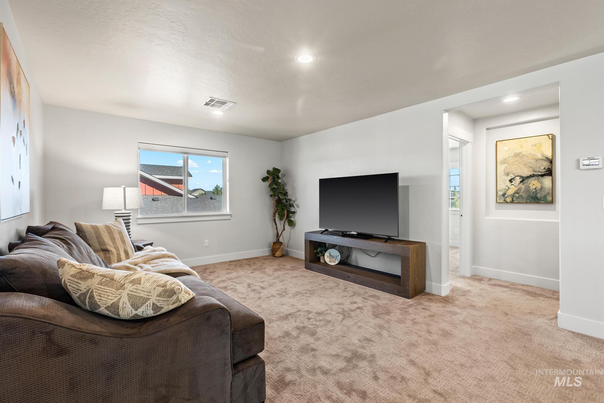 Carpeted living room with baseboards and recessed lighting