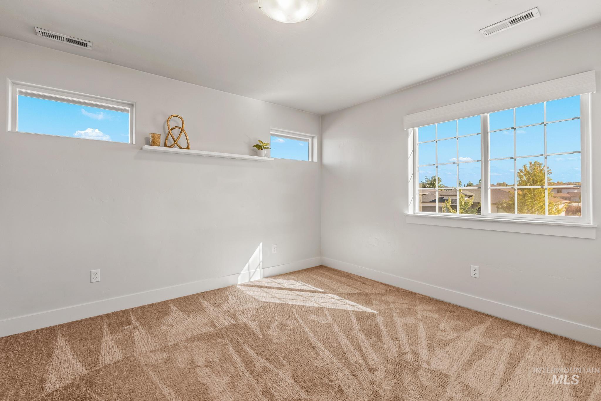 Empty room with baseboards and light colored carpet