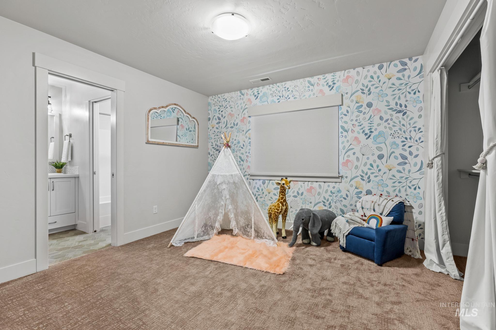 Rec room featuring wallpapered walls, carpet, and a textured ceiling