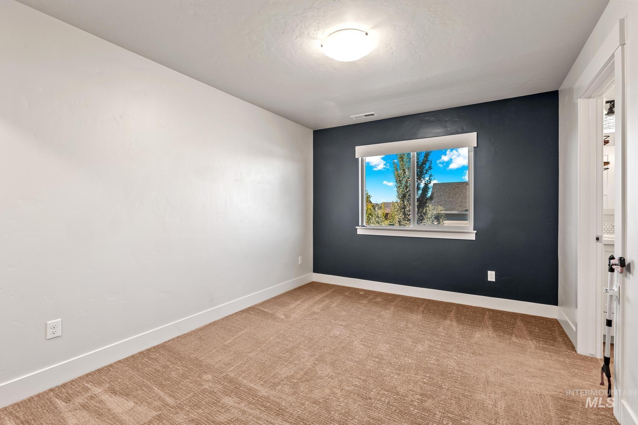 Spare room featuring light colored carpet and a textured ceiling