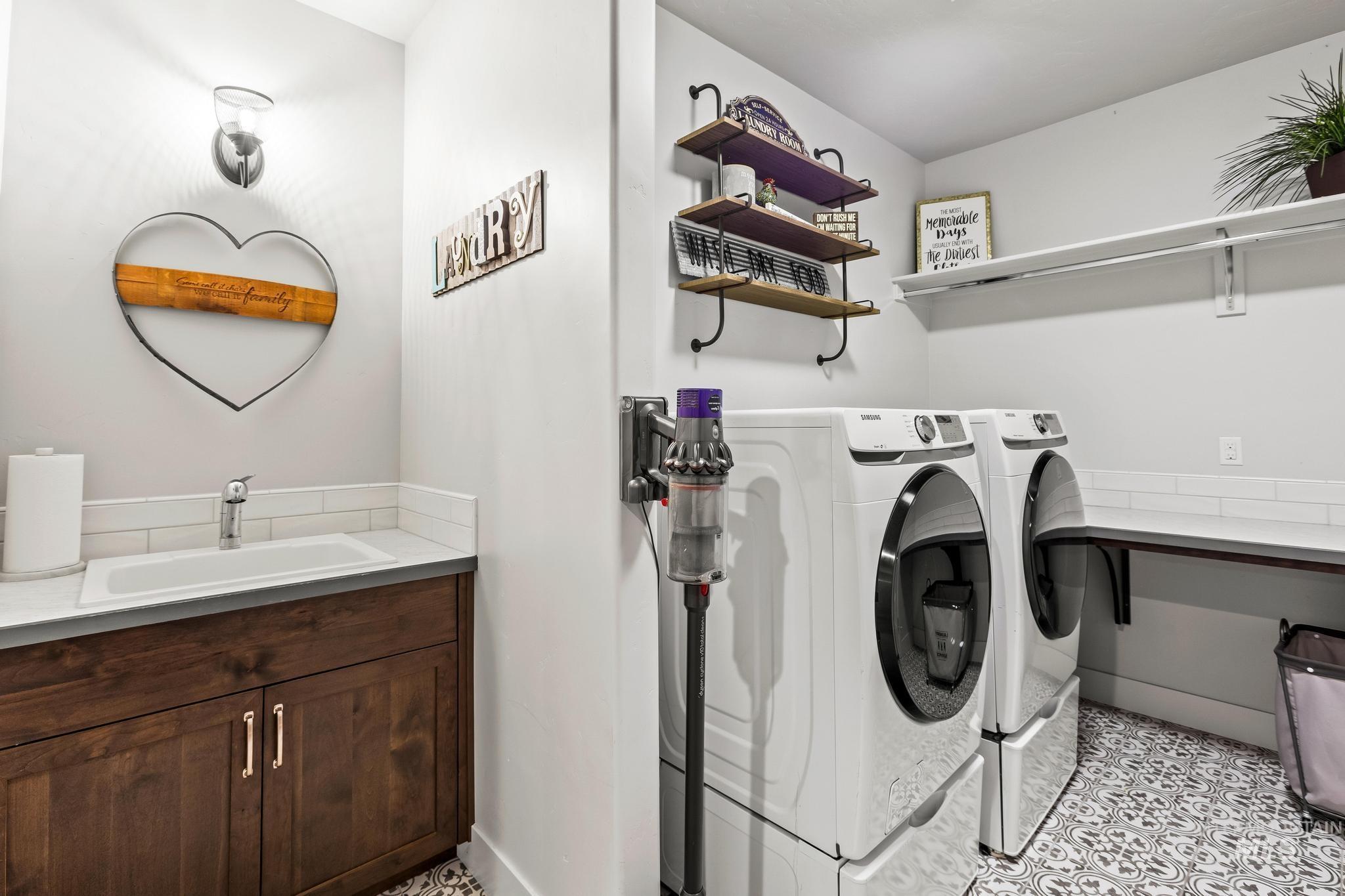 Laundry room with independent washer and dryer and light tile patterned floors