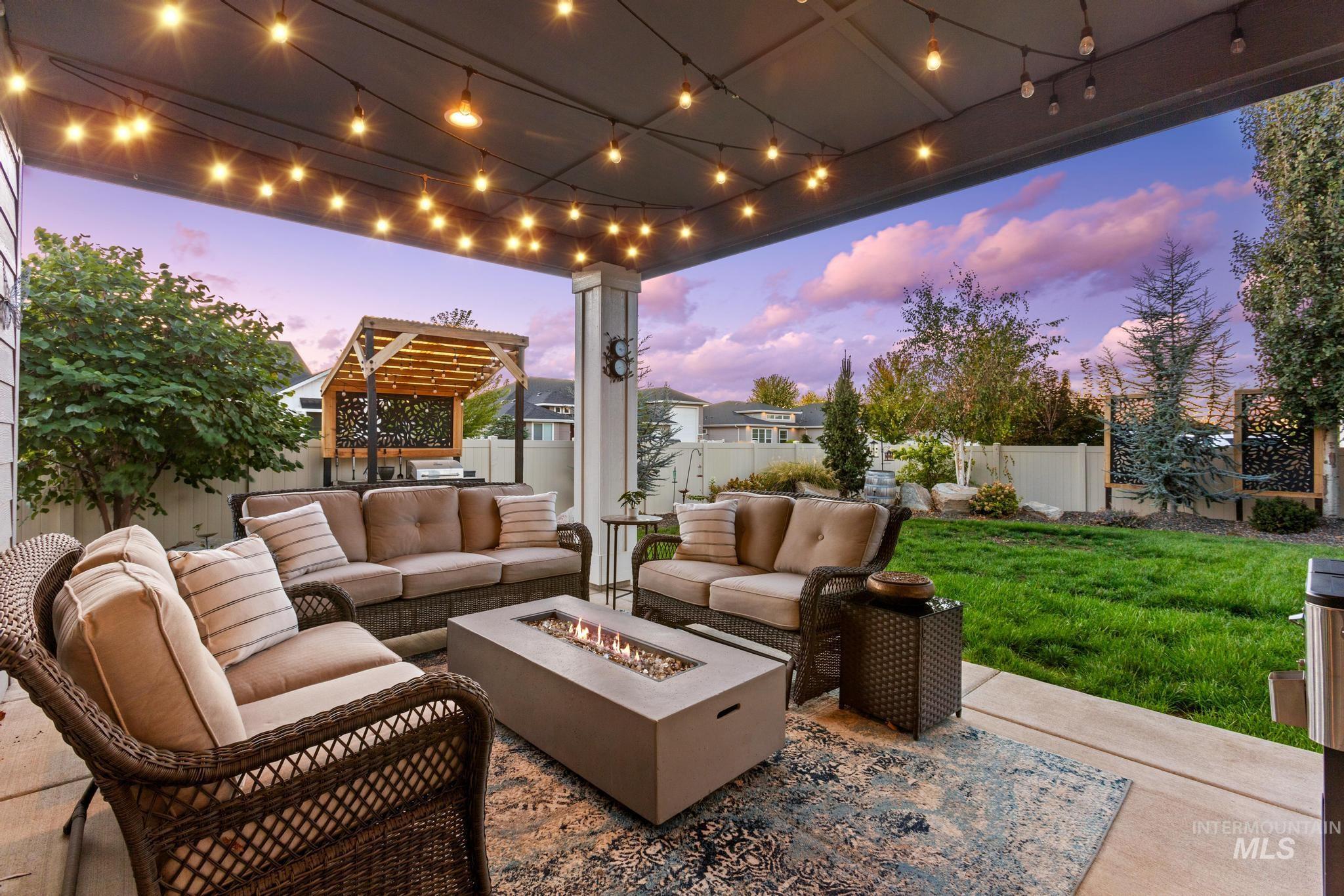 Fenced backyard with an outdoor living space with a fire pit and a patio area