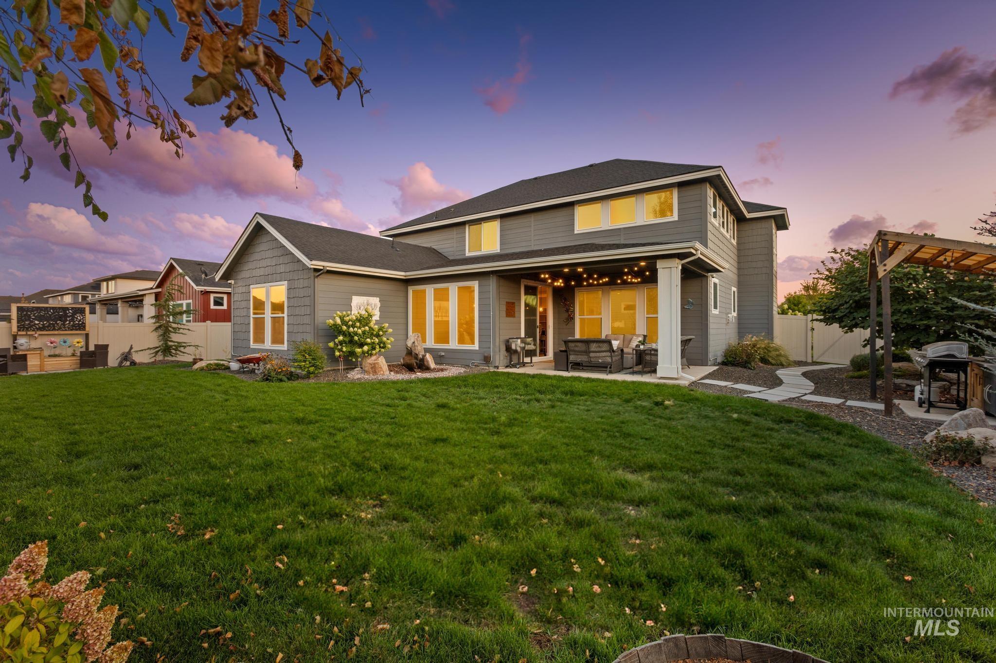 Back of house at dusk featuring a patio, an outdoor hangout area, and a pergola