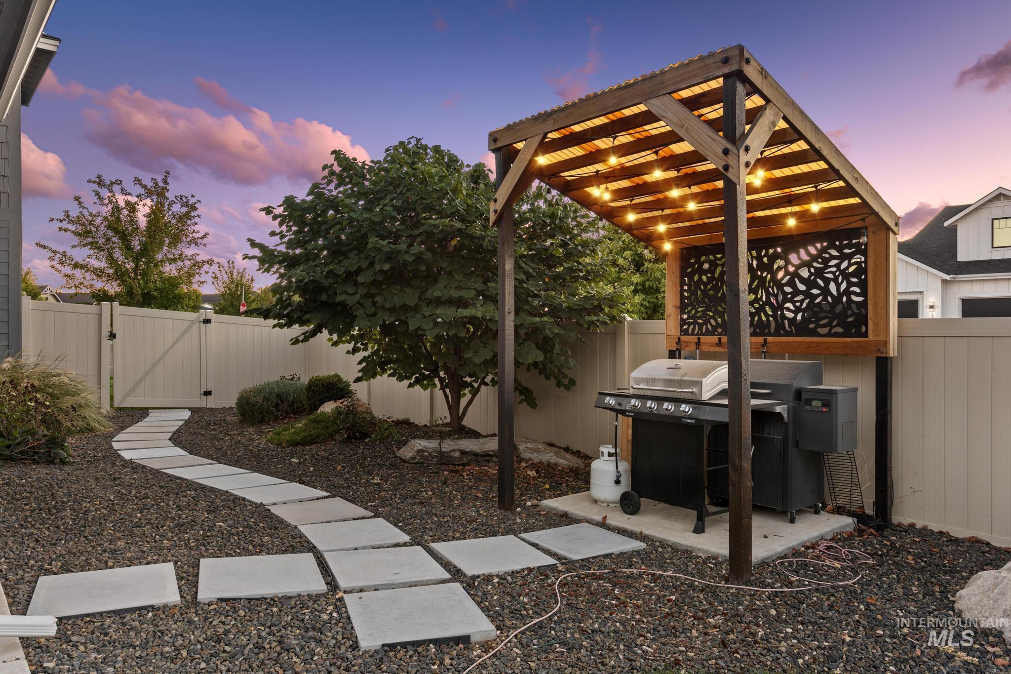 Patio terrace at dusk featuring a gate, grilling area, and a patio