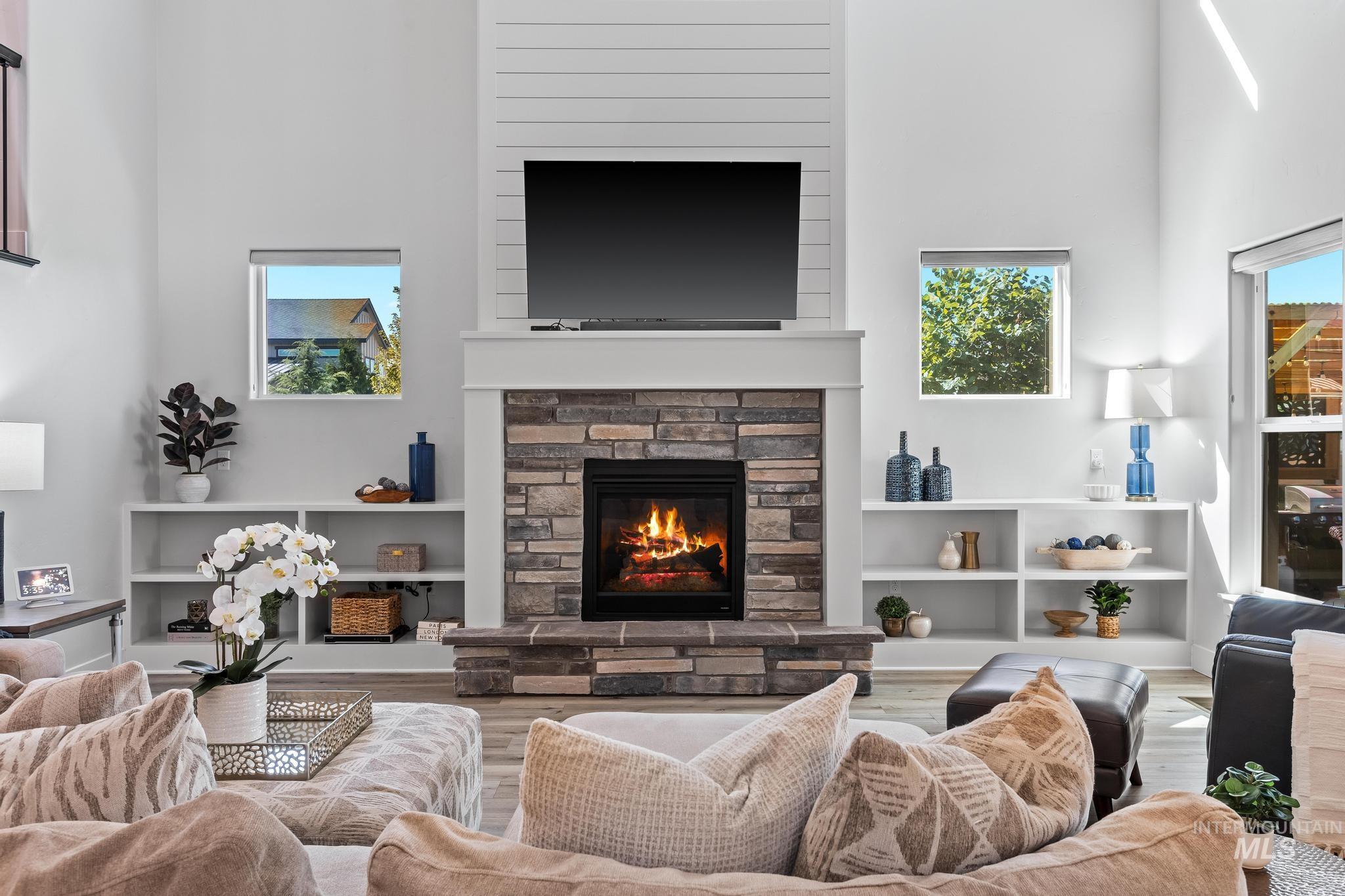Living area with a high ceiling, a fireplace, and wood finished floors
