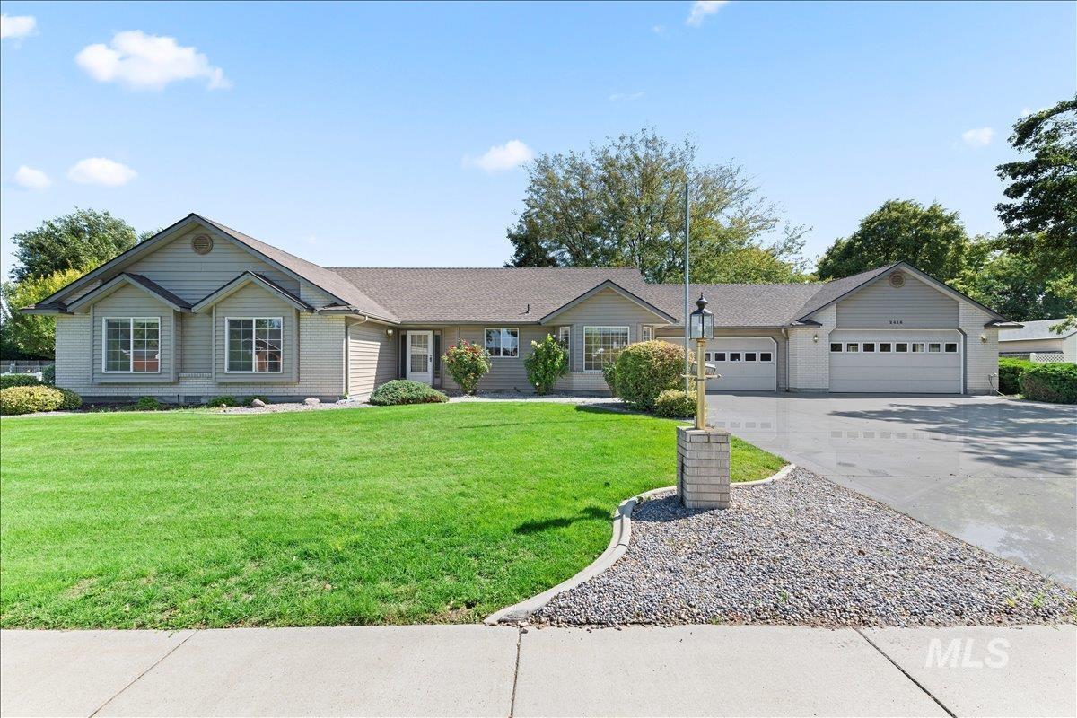 Single story home with driveway, a front yard, and an attached garage