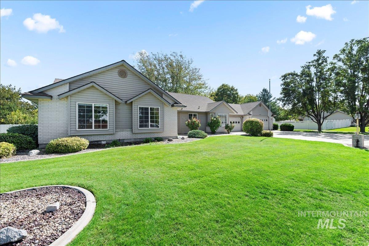 Ranch-style house featuring concrete driveway and a front yard