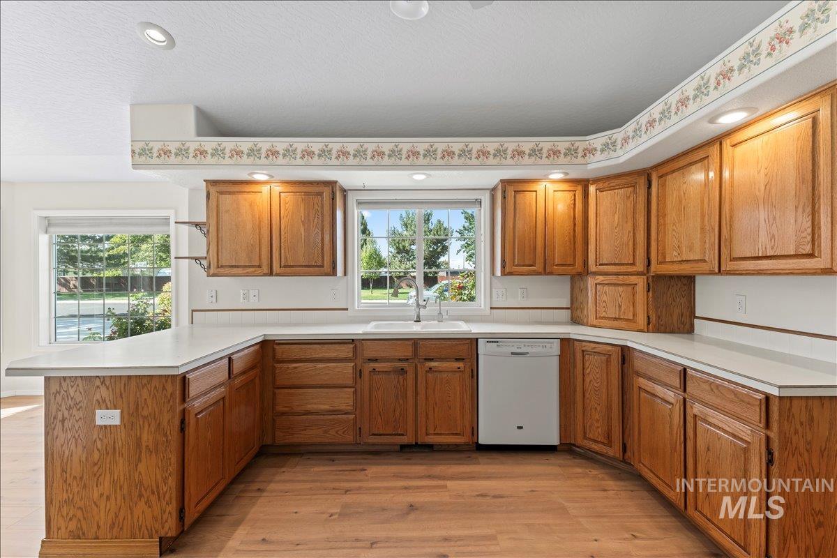 Kitchen featuring brown cabinets, light wood-type flooring, light countertops, and recessed lighting