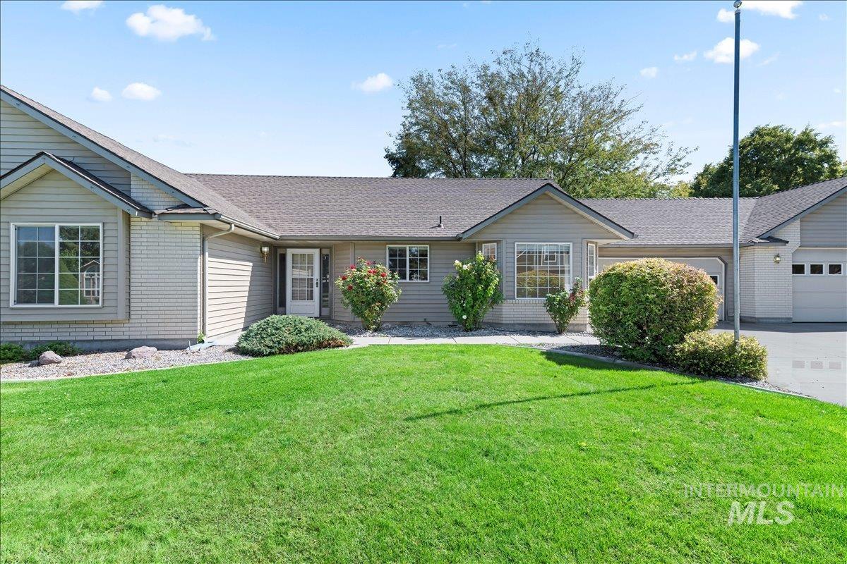 Single story home with a front yard, a shingled roof, a garage, and concrete driveway