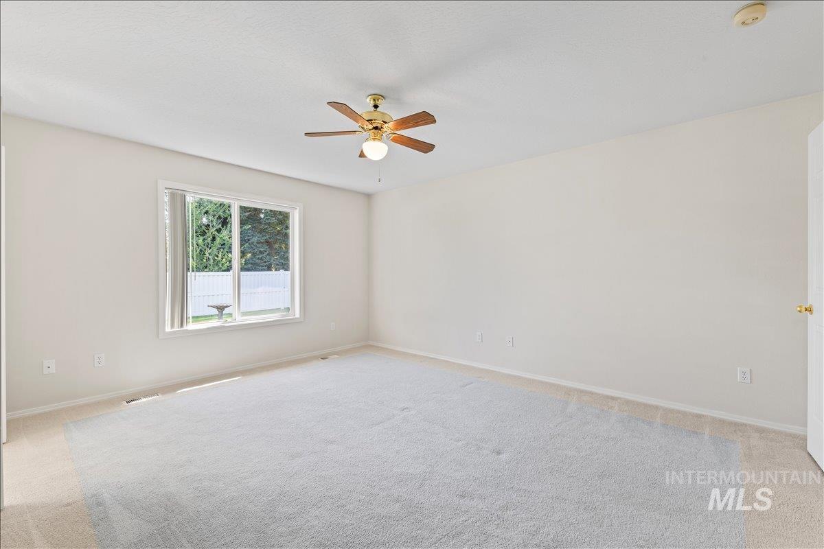 Unfurnished room with light carpet and a ceiling fan