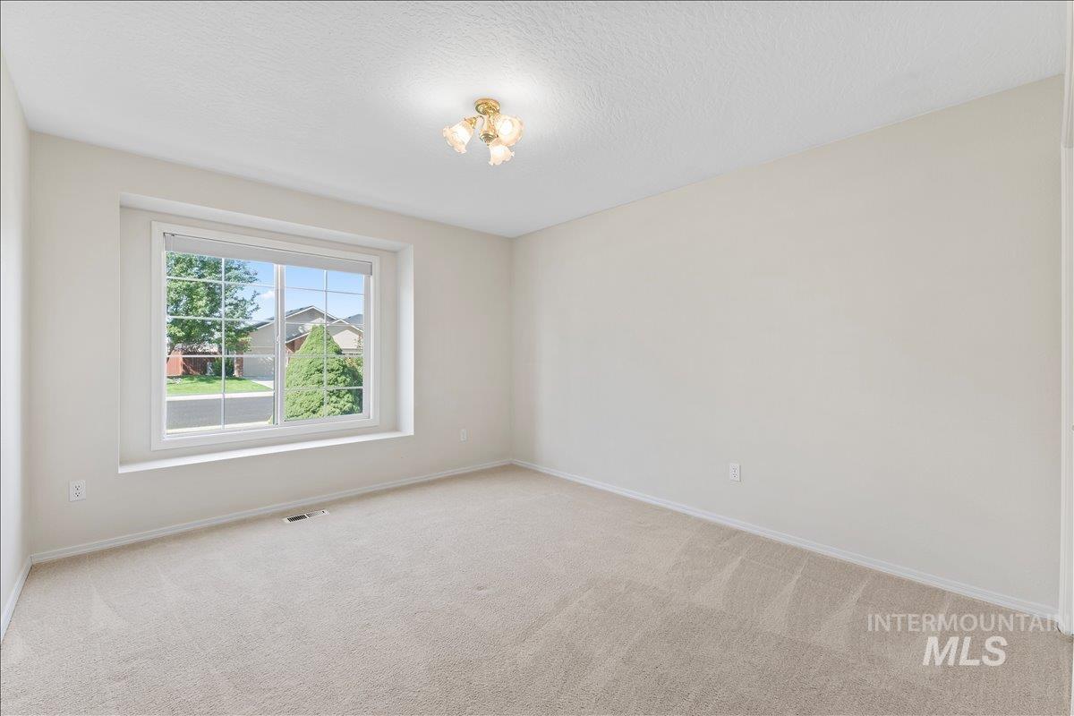 Carpeted empty room featuring baseboards and a textured ceiling