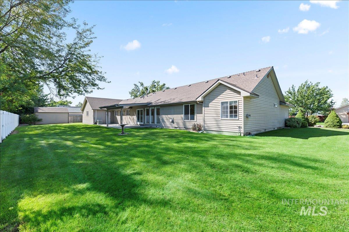 Back of house featuring a patio and roof with shingles