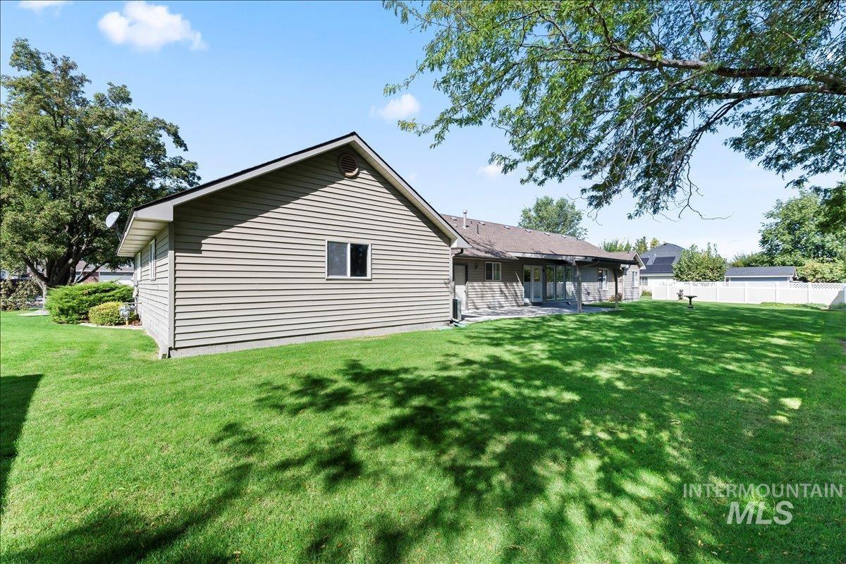 View of side of property featuring a lawn and a patio area