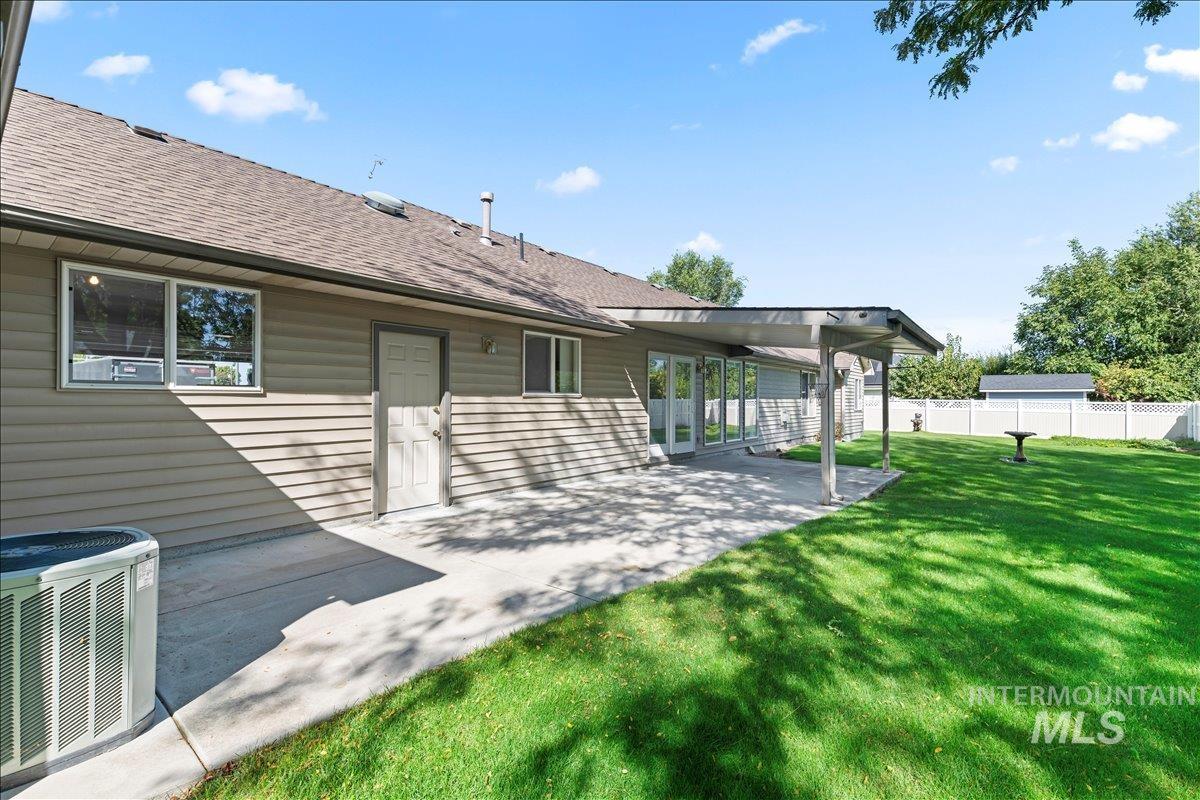 Back of property with a patio and a shingled roof
