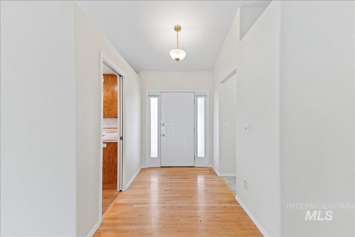 Foyer entrance featuring light wood-style flooring and baseboards