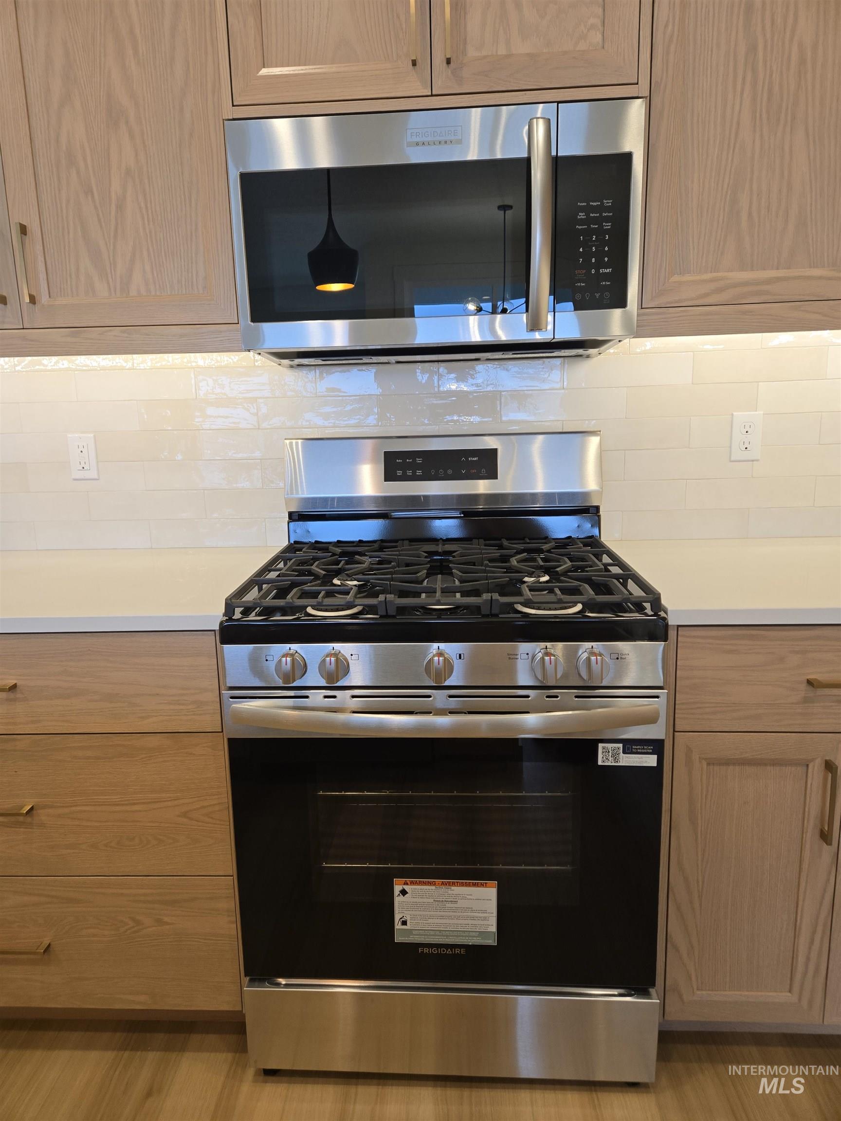 Kitchen featuring stainless steel appliances and backsplash
