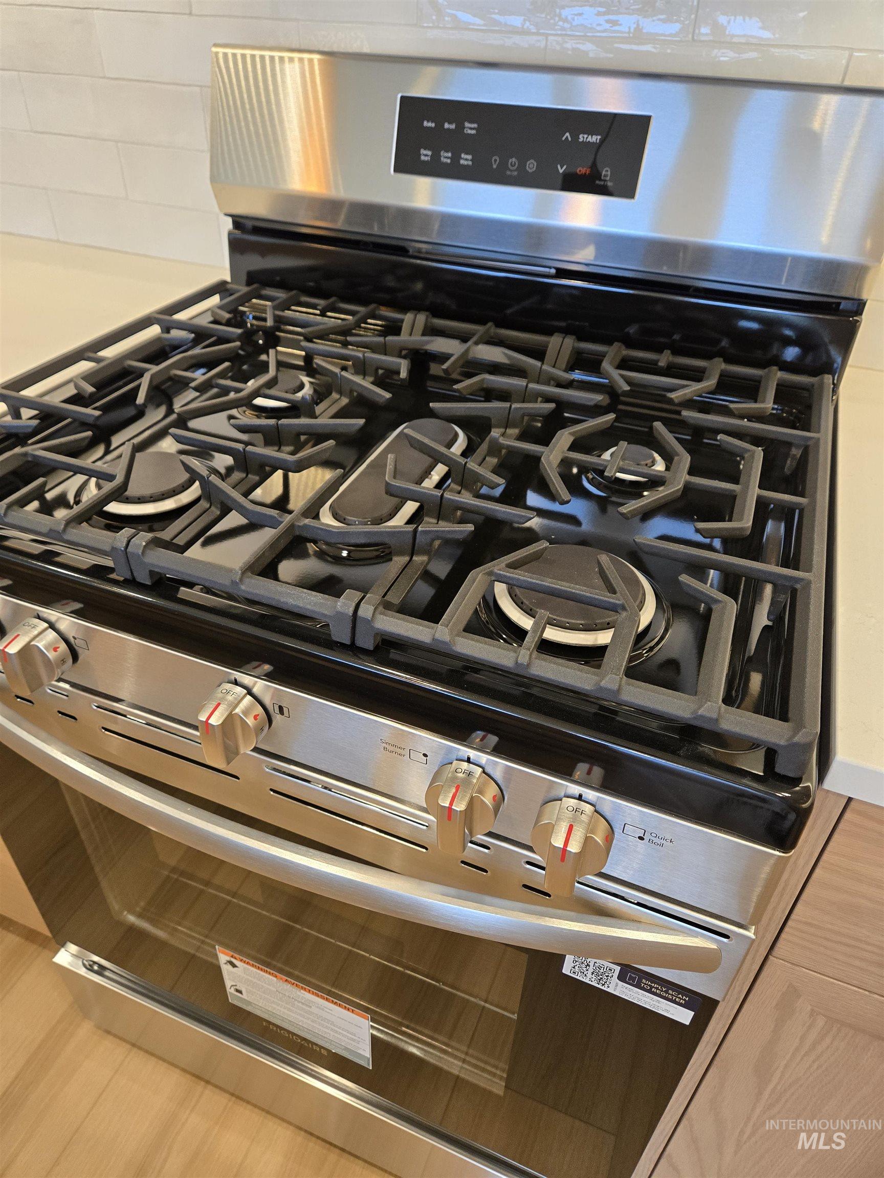 Kitchen view of gas range and light countertops