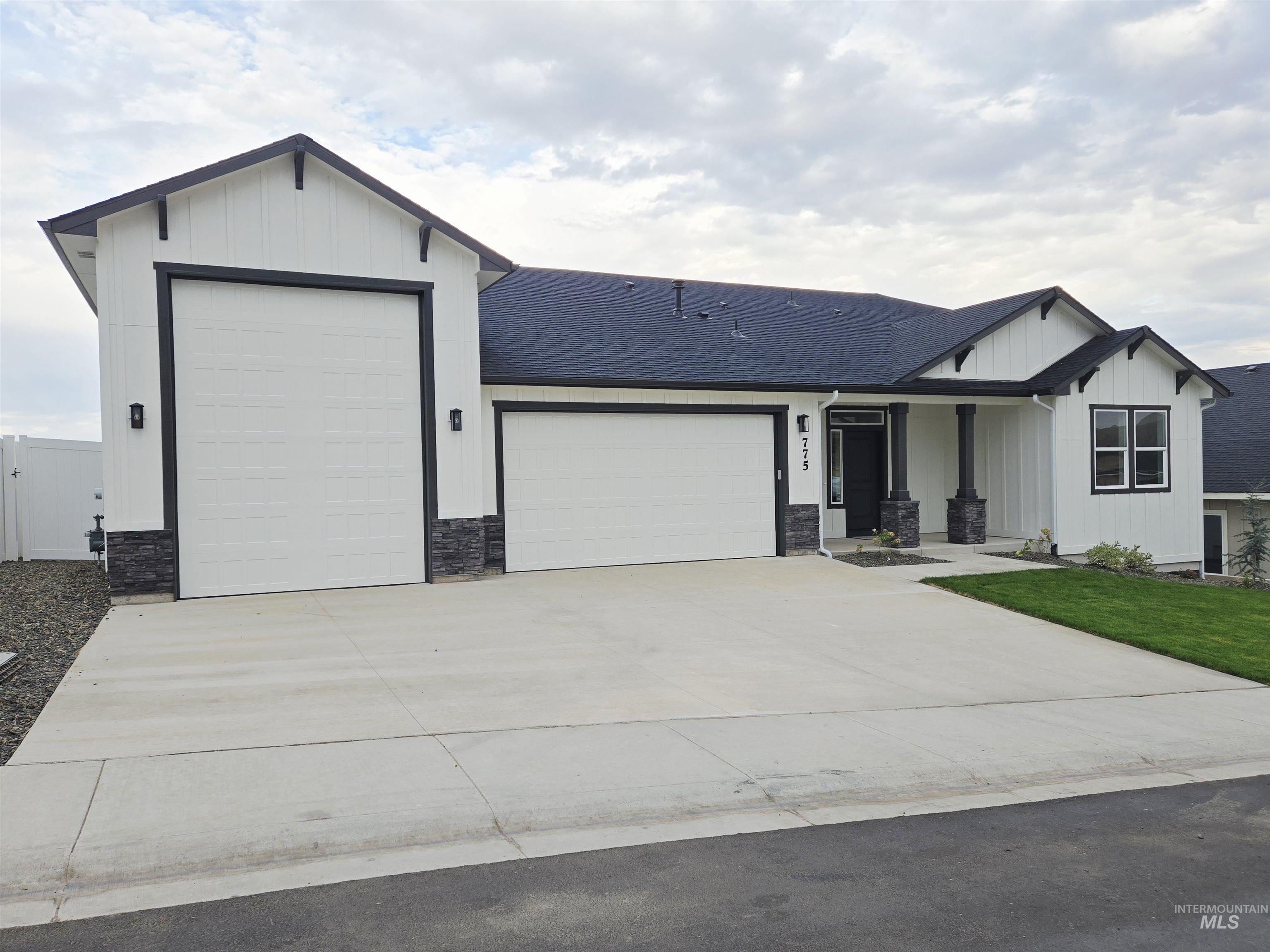View of front of home with a garage, a porch, stone siding, and a shingled roof