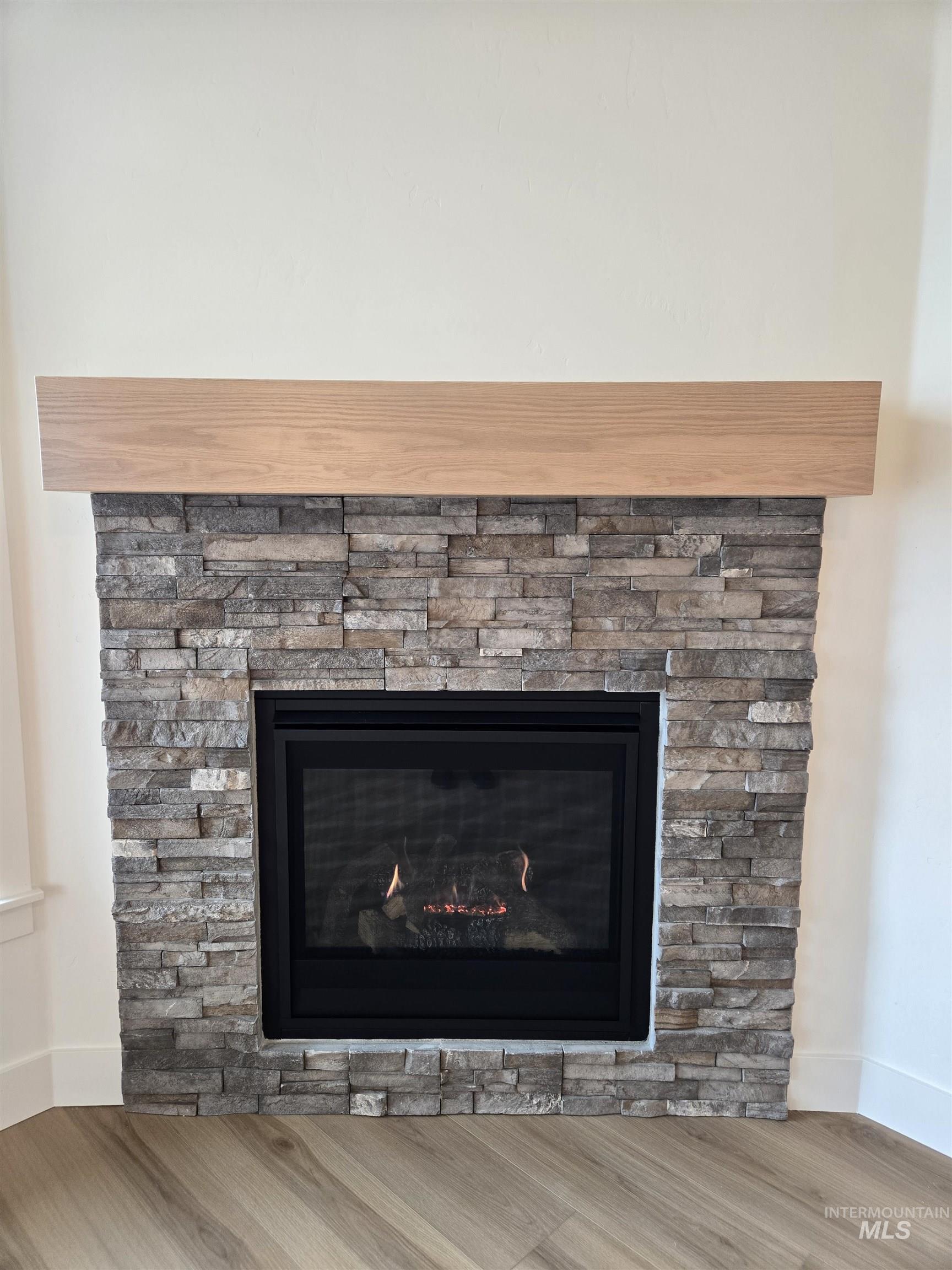 Detailed view of wood finished floors and a fireplace