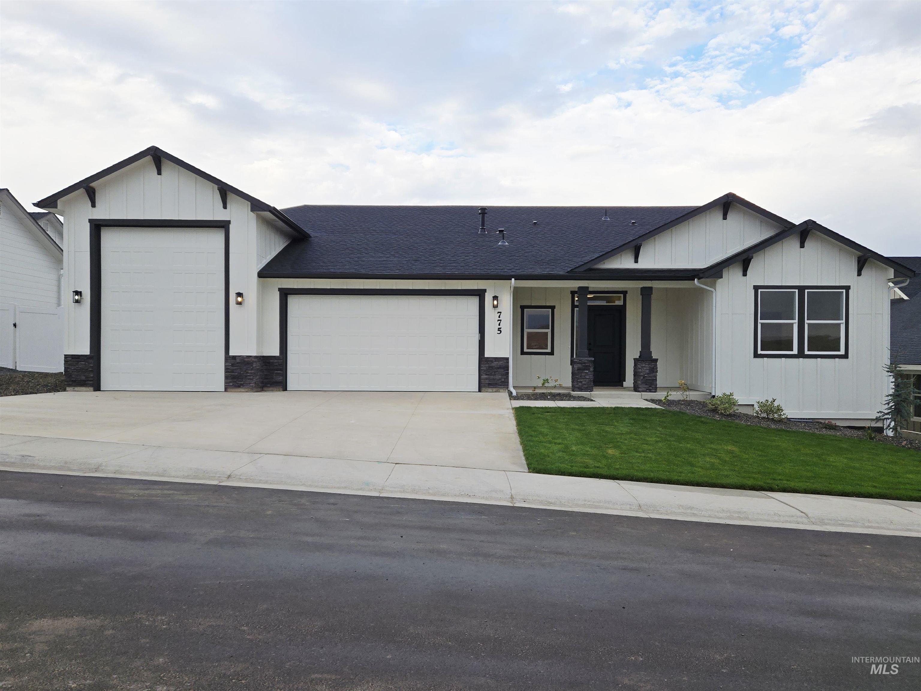 View of front of house featuring covered porch, board and batten siding, a garage, driveway, and roof with shingles