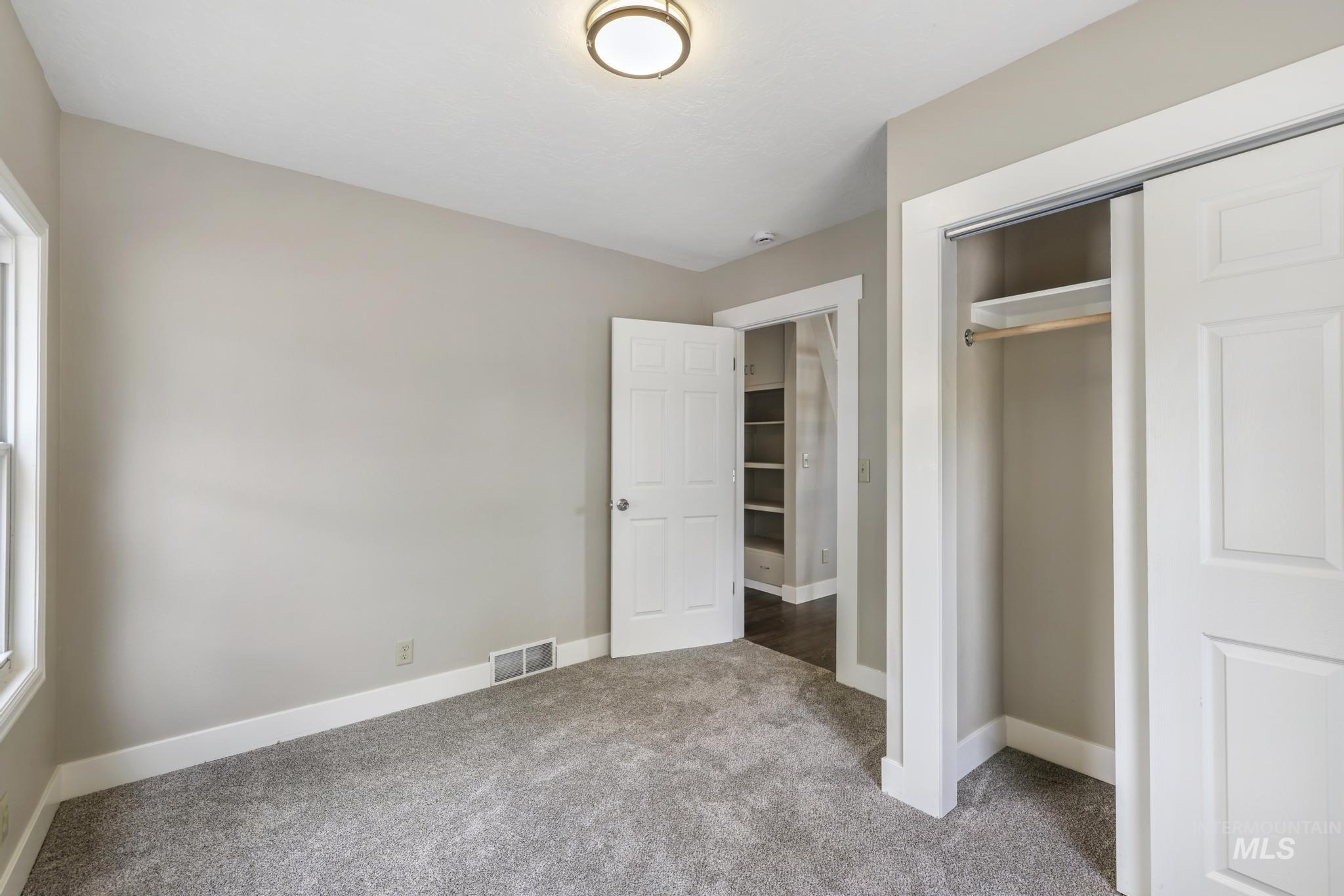 Unfurnished bedroom featuring carpet flooring and a closet