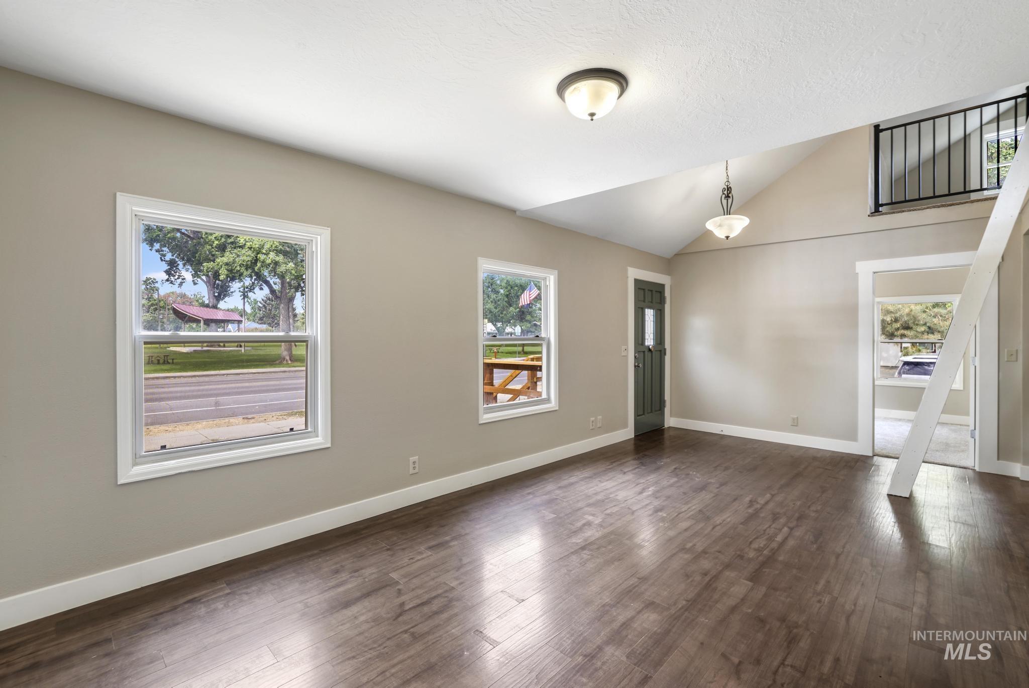 Entrance foyer featuring plenty of natural light, lofted ceiling, and dark wood finished floors