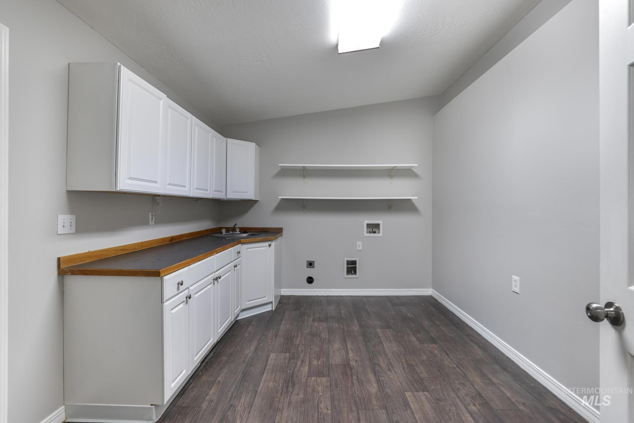 Laundry room featuring washer hookup, dark wood-type flooring, cabinet space, and hookup for an electric dryer