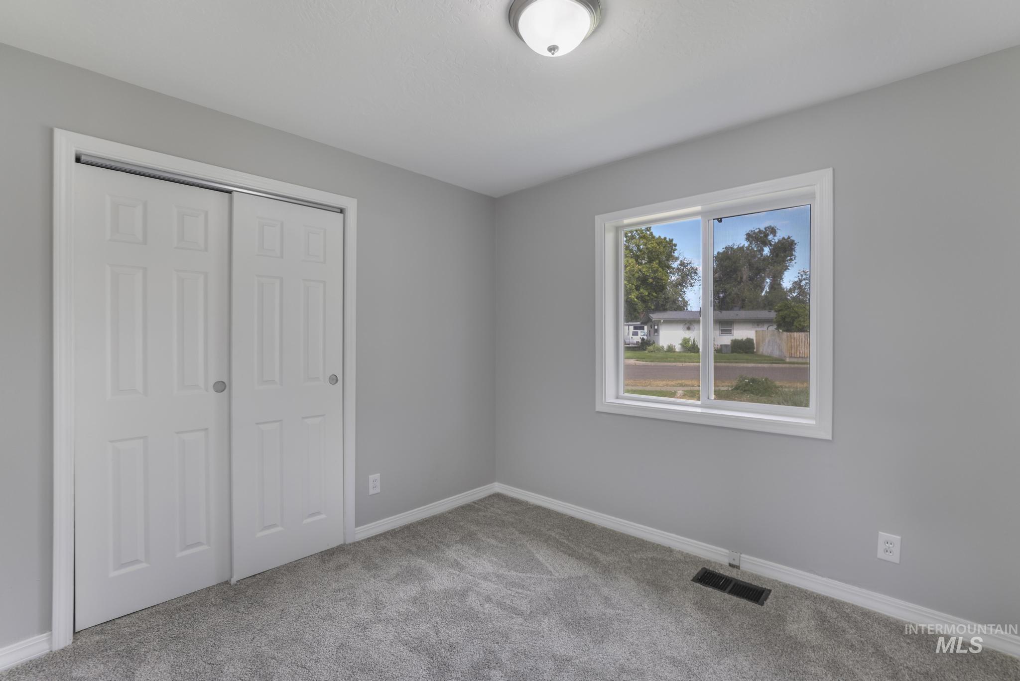 Unfurnished bedroom with light colored carpet and a closet