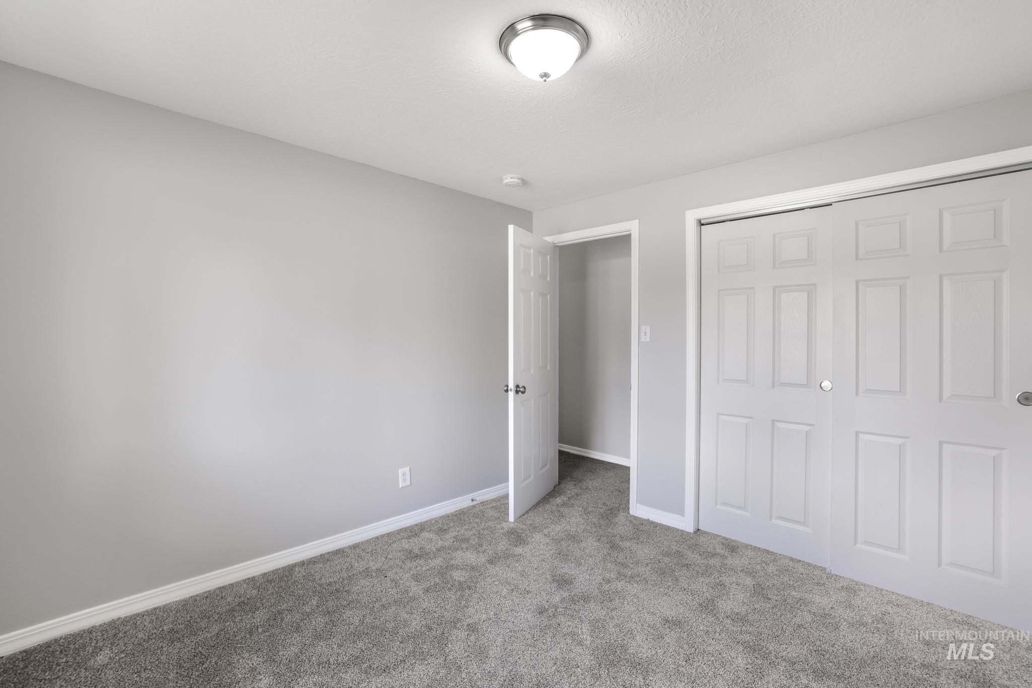 Unfurnished bedroom featuring carpet floors, a closet, and a textured ceiling