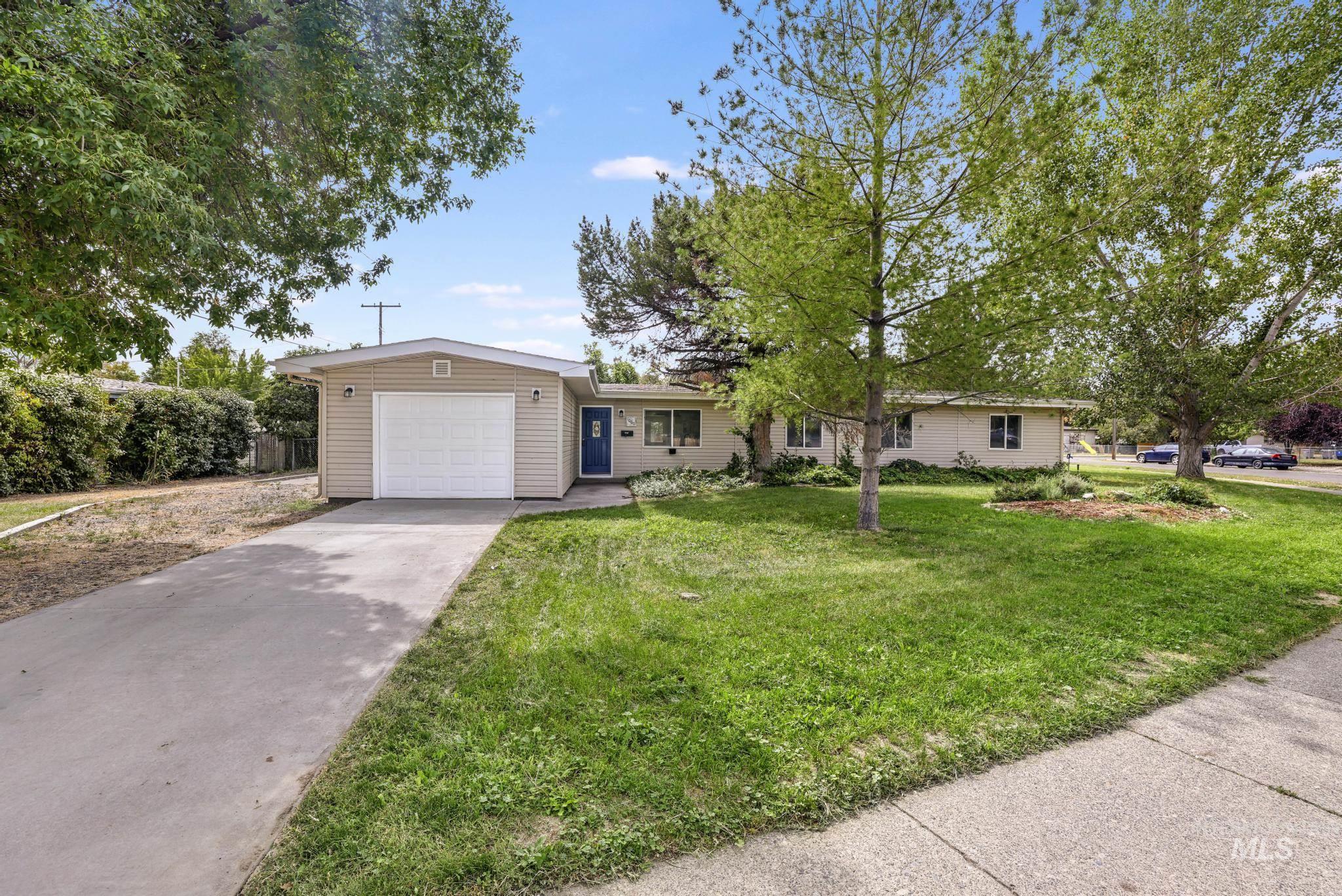 Single story home with driveway, a front yard, and a garage