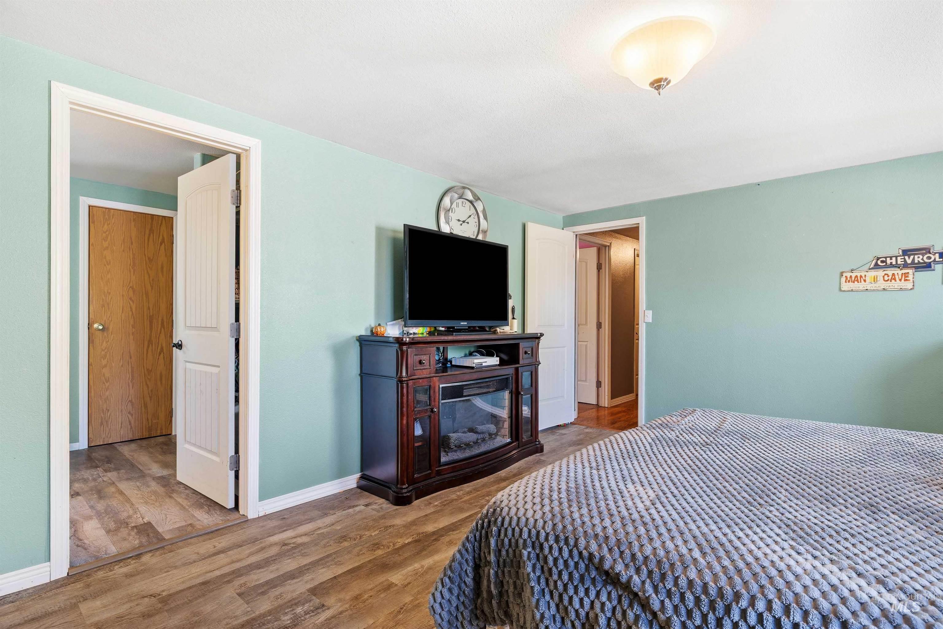 Bedroom with wood finished floors and baseboards