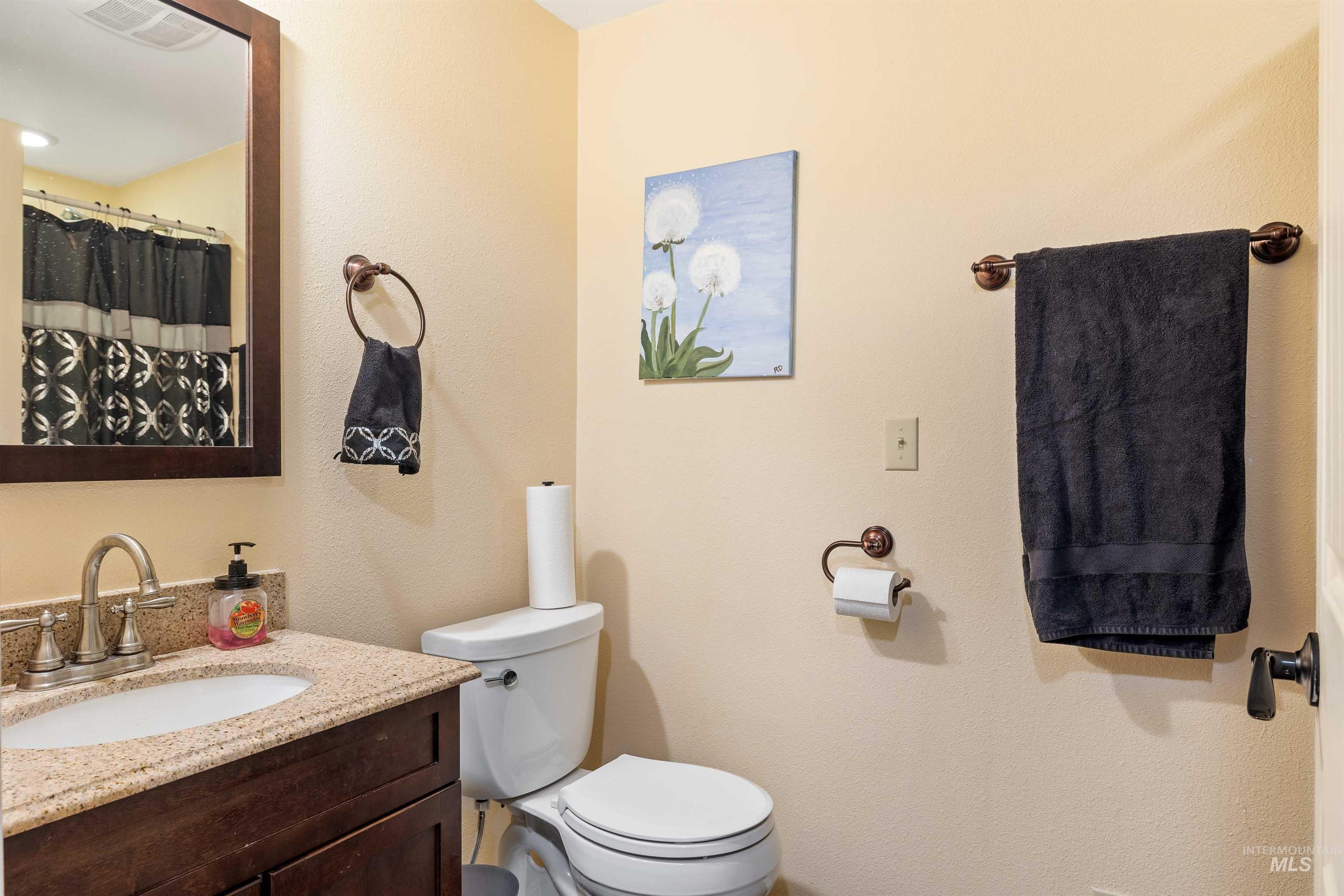 Bathroom with vanity, a textured wall, and a shower with shower curtain