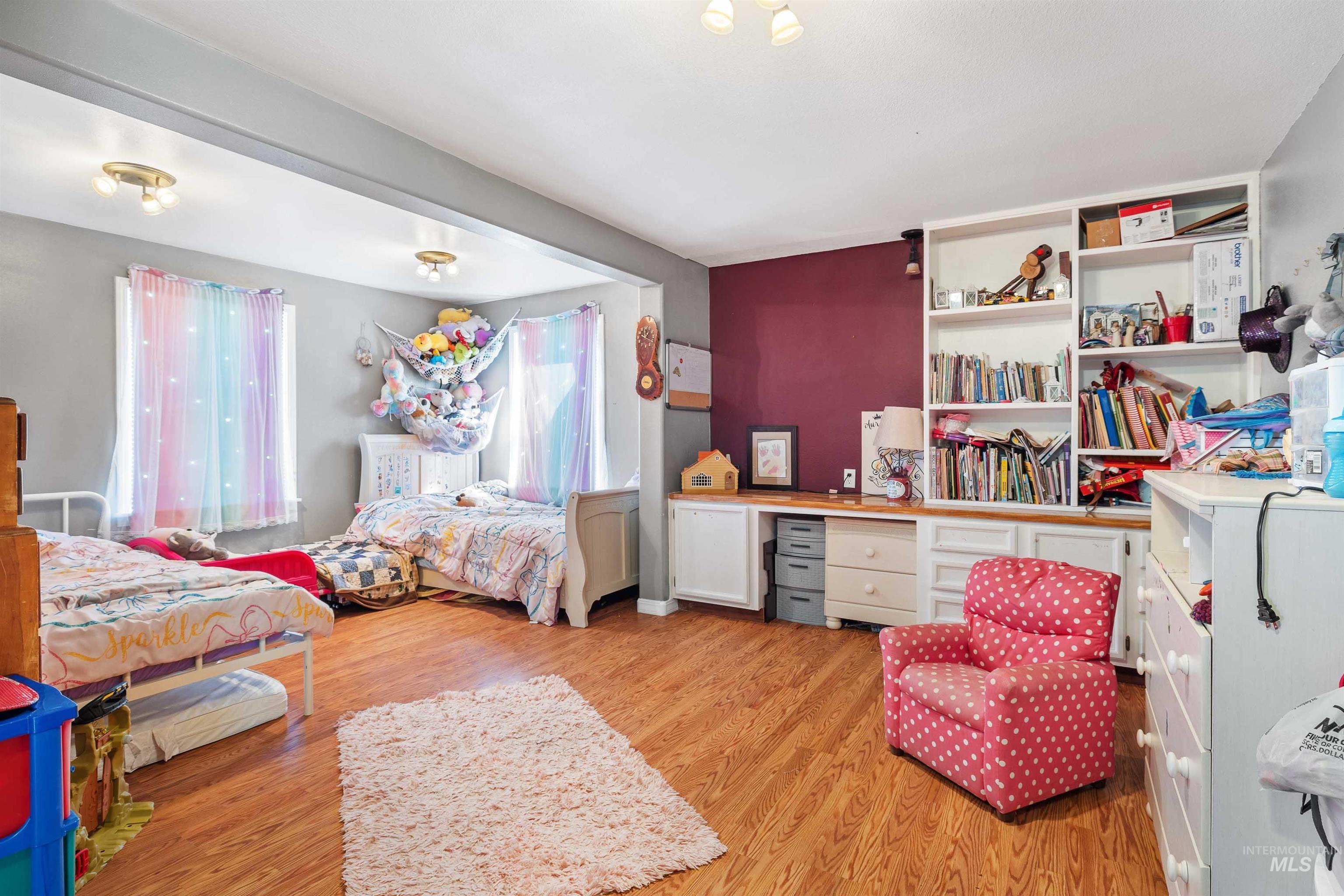 Bedroom with light wood-type flooring and multiple windows